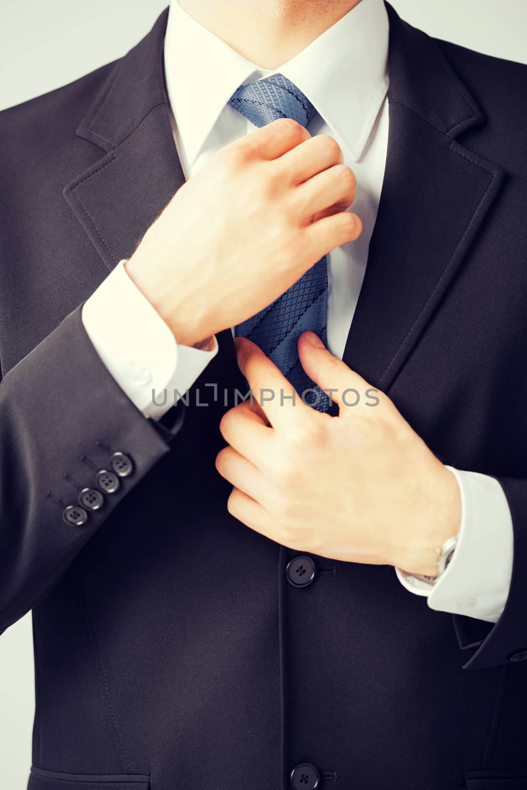 man adjusting his tie by dolgachov