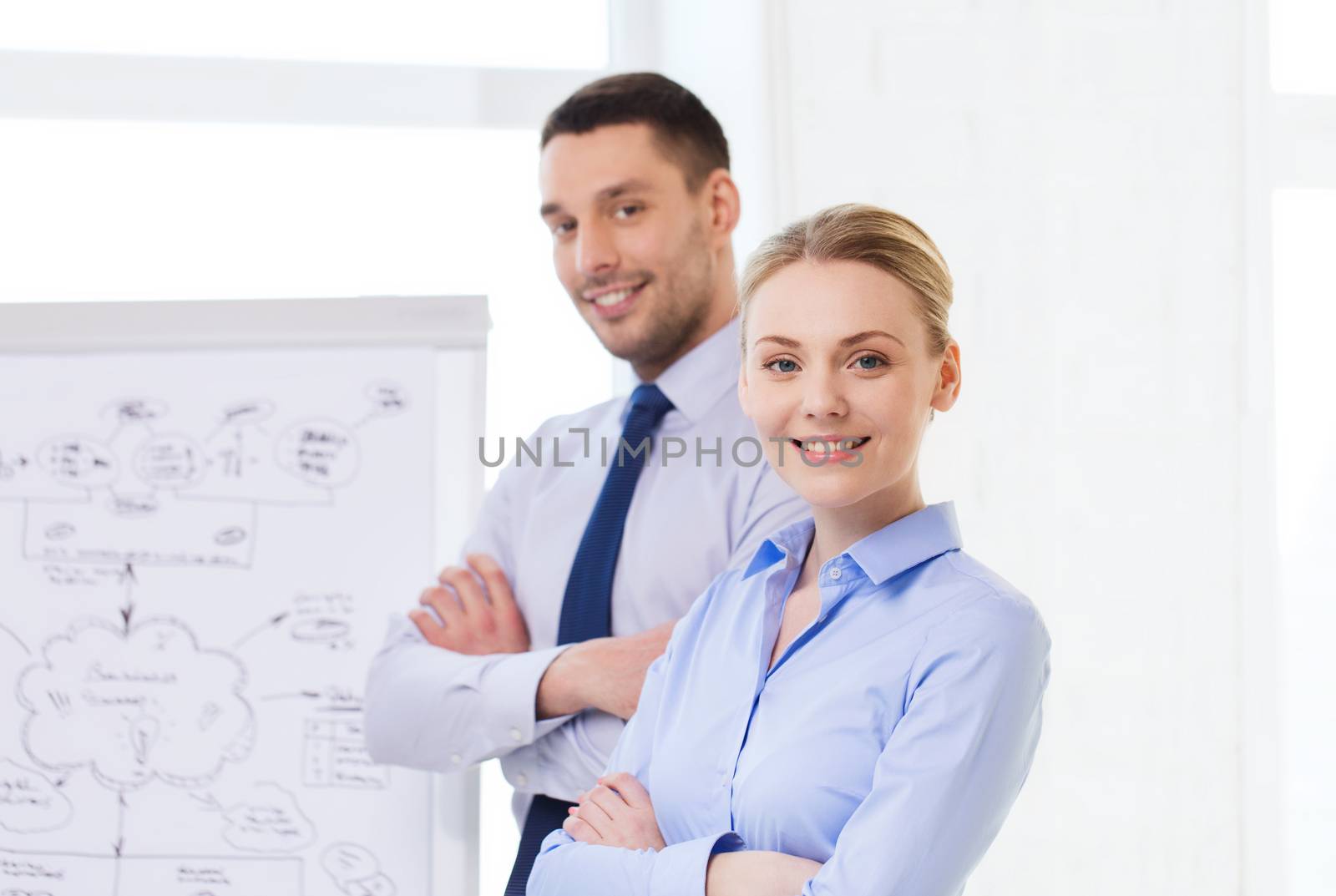 business, teamwork and people concept - smiling businessman and businesswoman in office