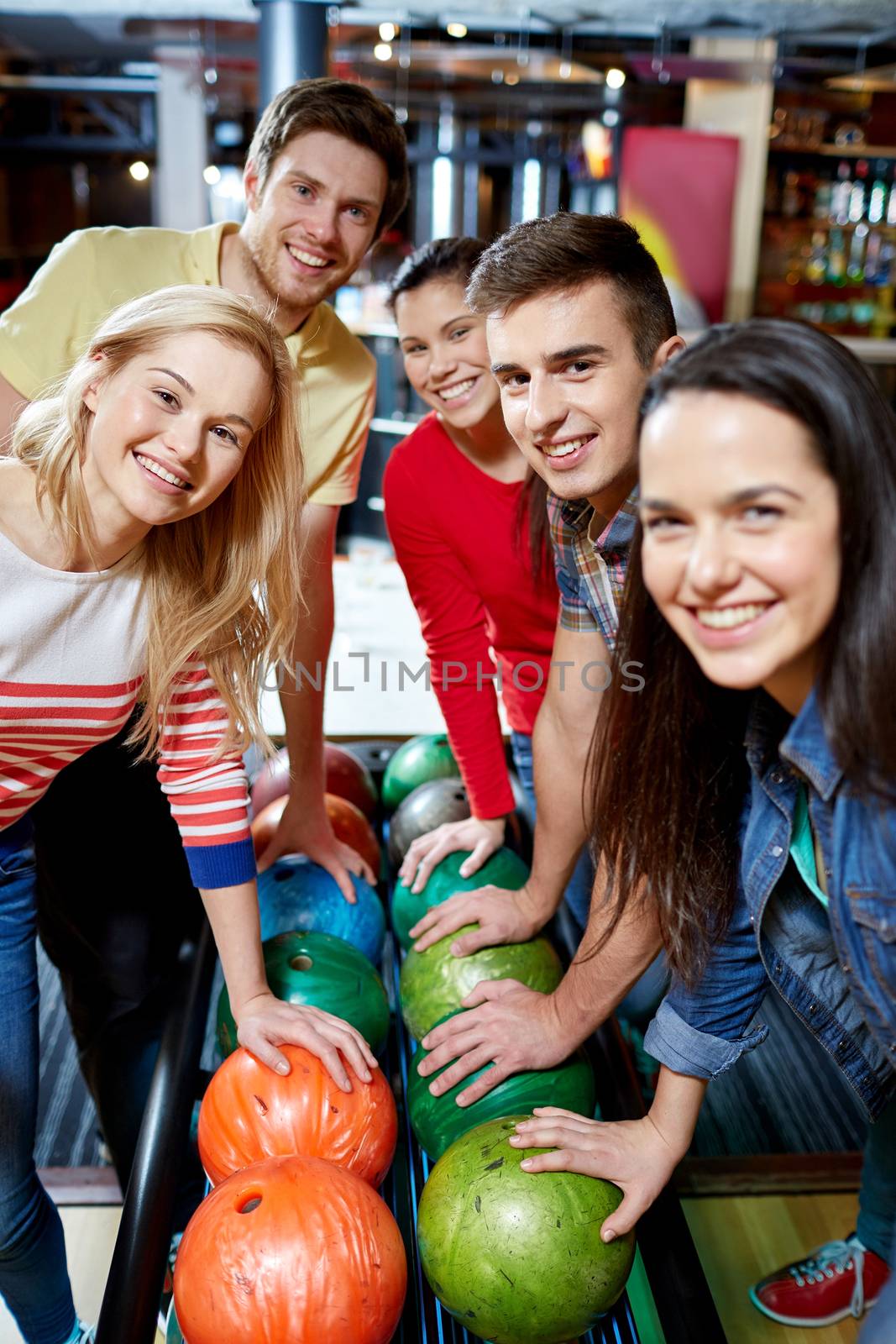 people, leisure, sport, friendship and entertainment concept - happy friends in bowling club