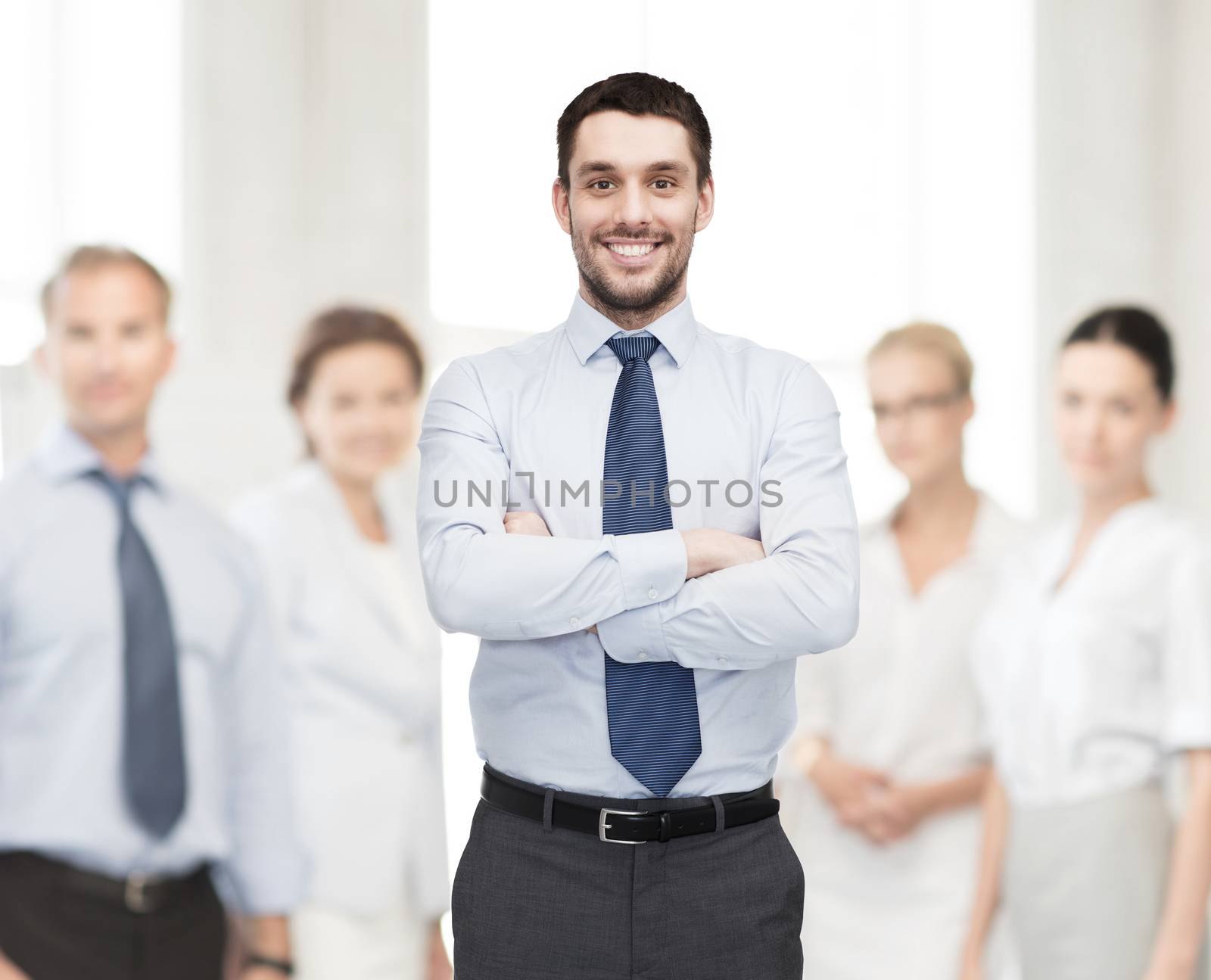 handsome businessman with crossed arms by dolgachov