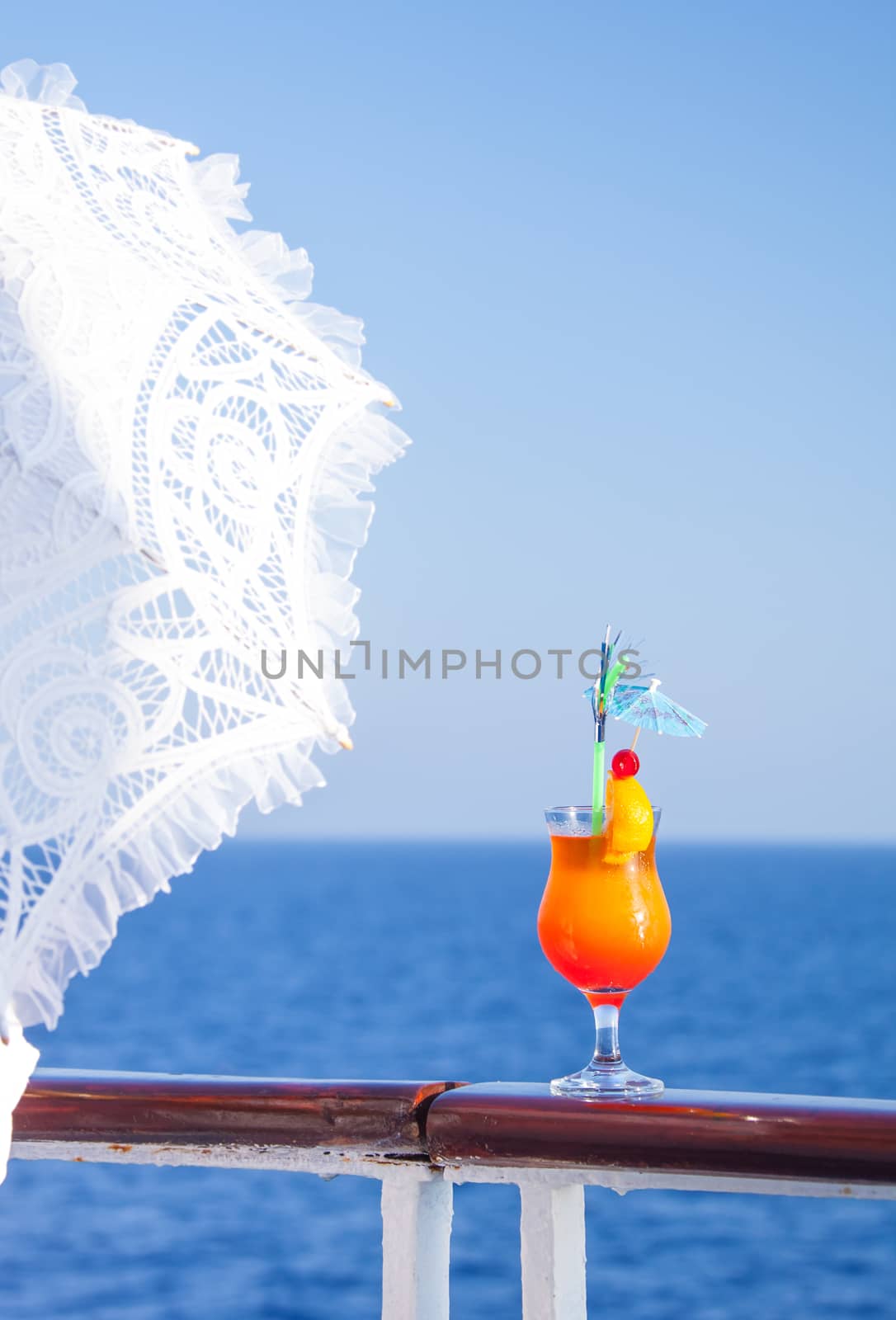 Girl with an umbrella to enjoy the journey drinking a cold cocktail