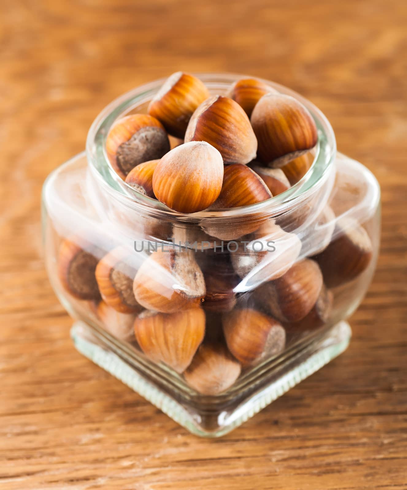 hazelnuts in a glass jar on a wooden background