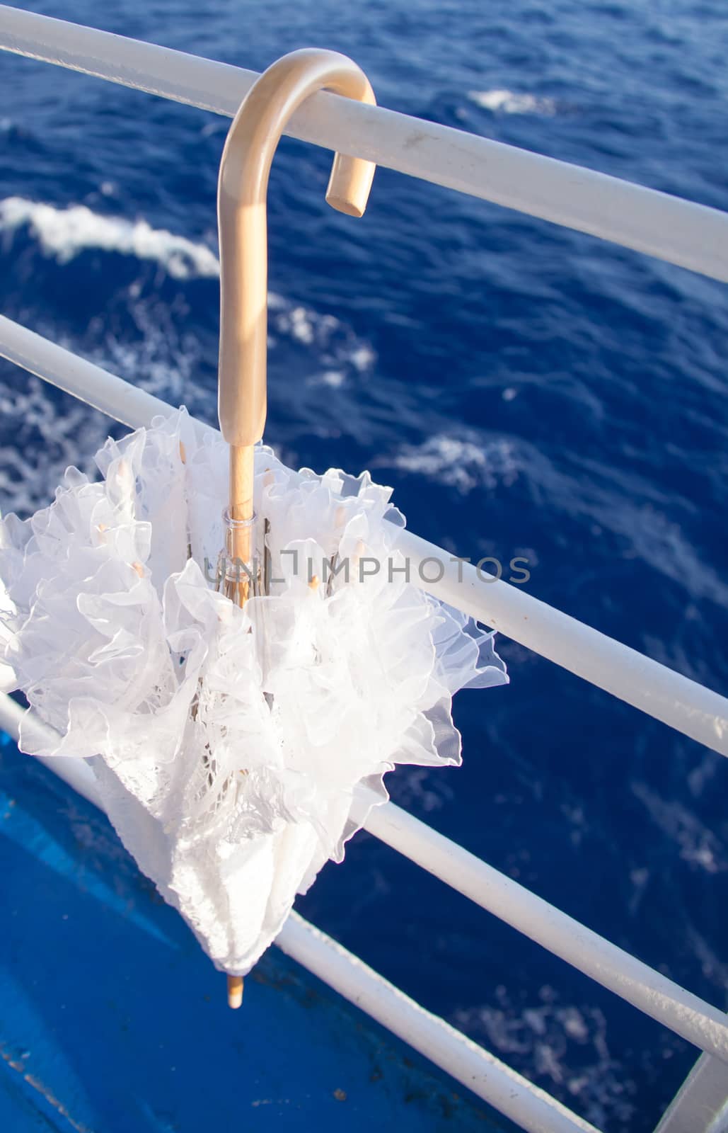 lonely, relaxing umbrella hanging on the railing of cruise liner