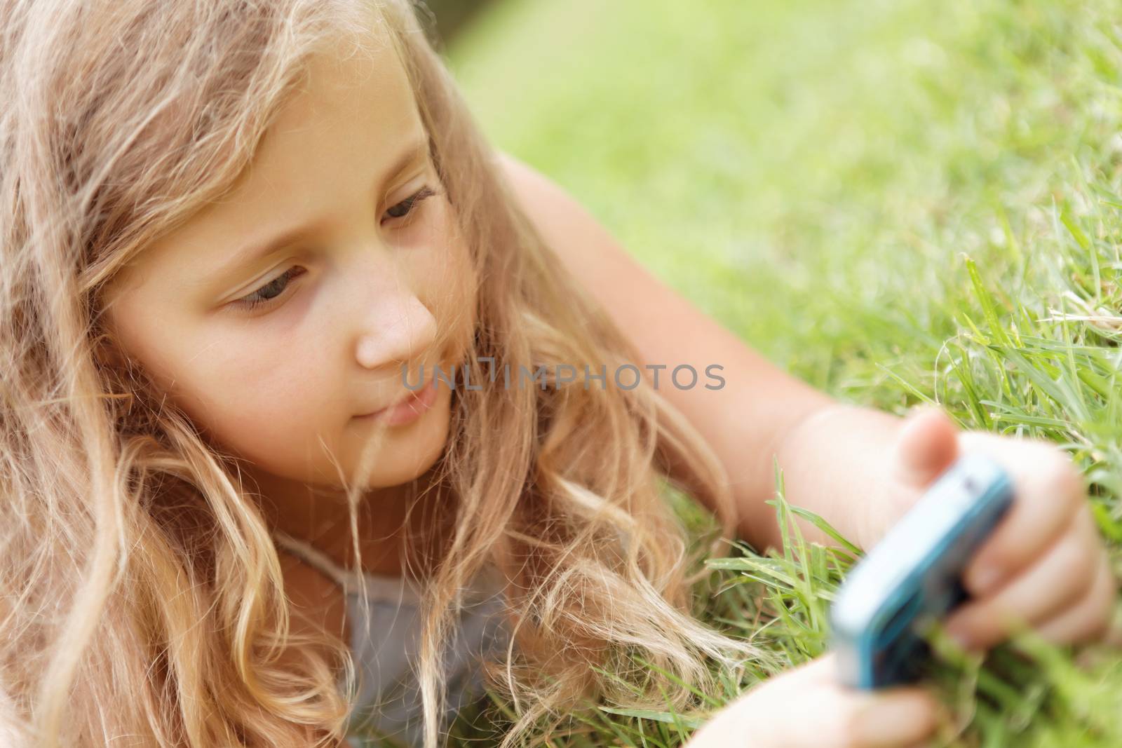 pretty baby girl outdoors with a mobile phone