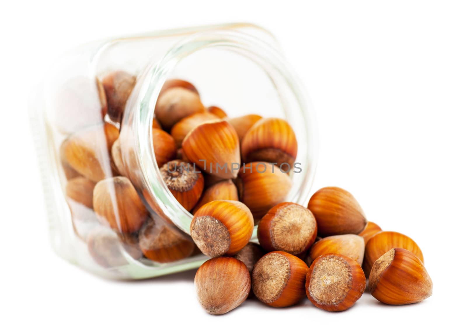 hazelnuts in a glass jar isolated on white background