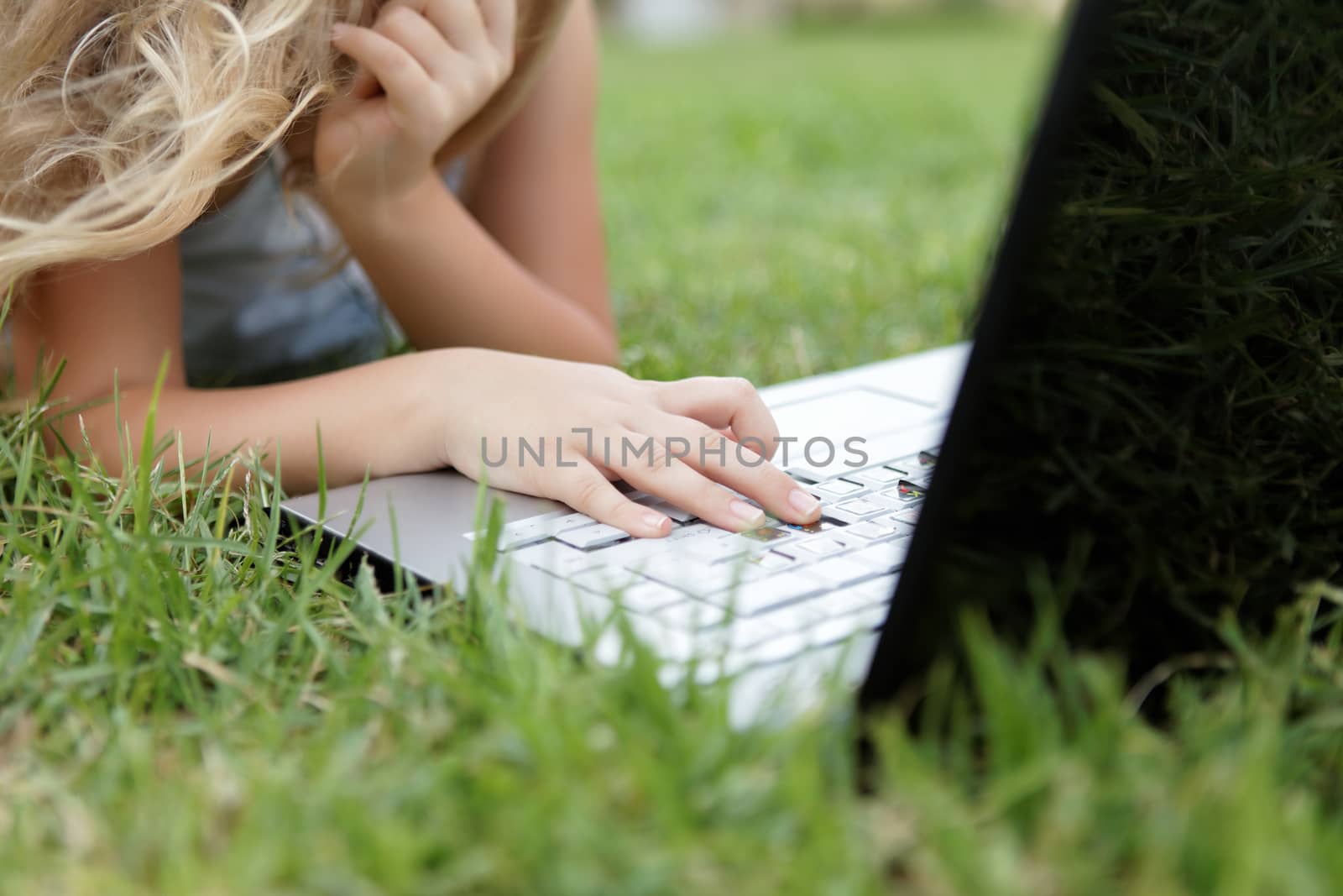 blond child girl with laptop outdoors