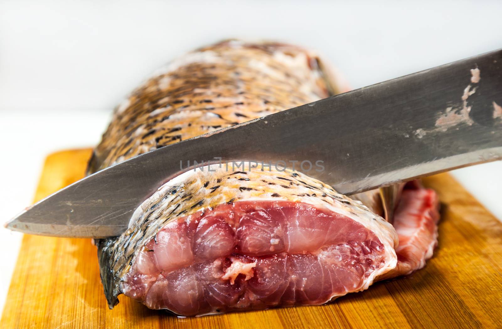  fish lying on the kitchen board with knife