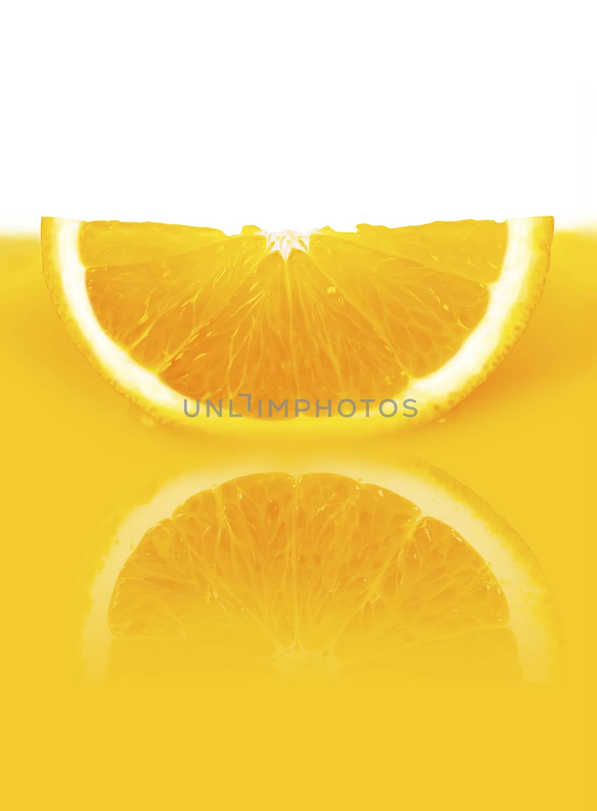 a slice of orange lying in a yellow orange juice