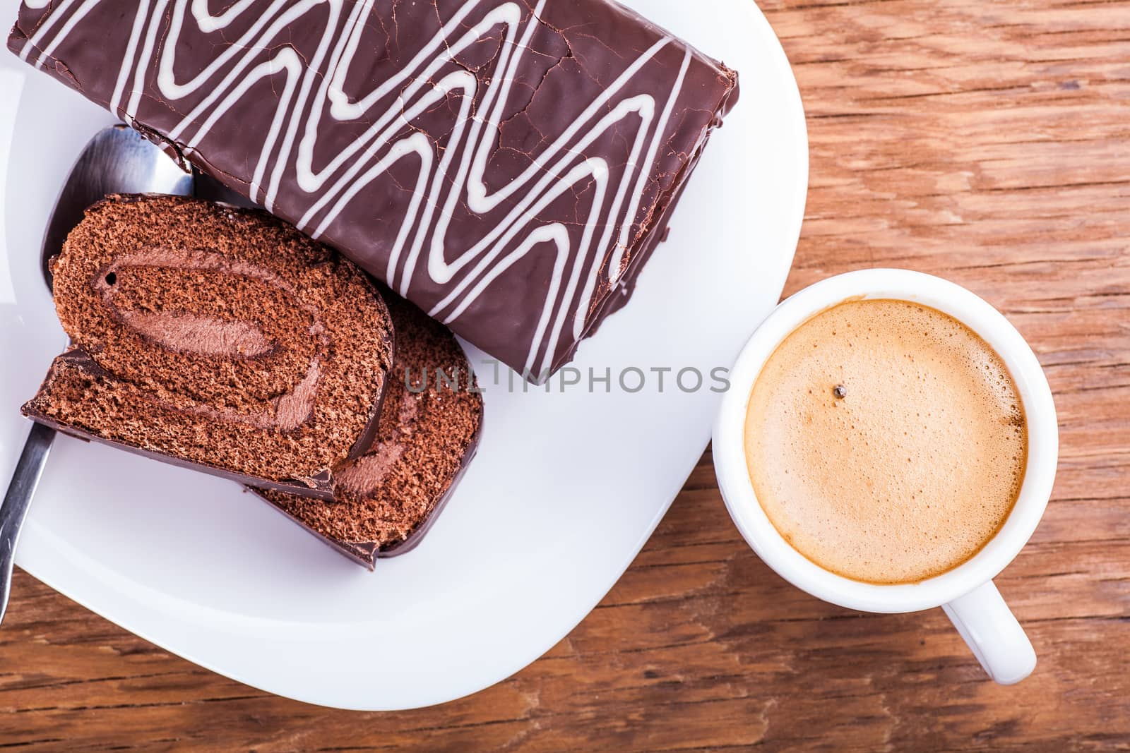 sweet roll with a cup of coffee close-up on a wooden background