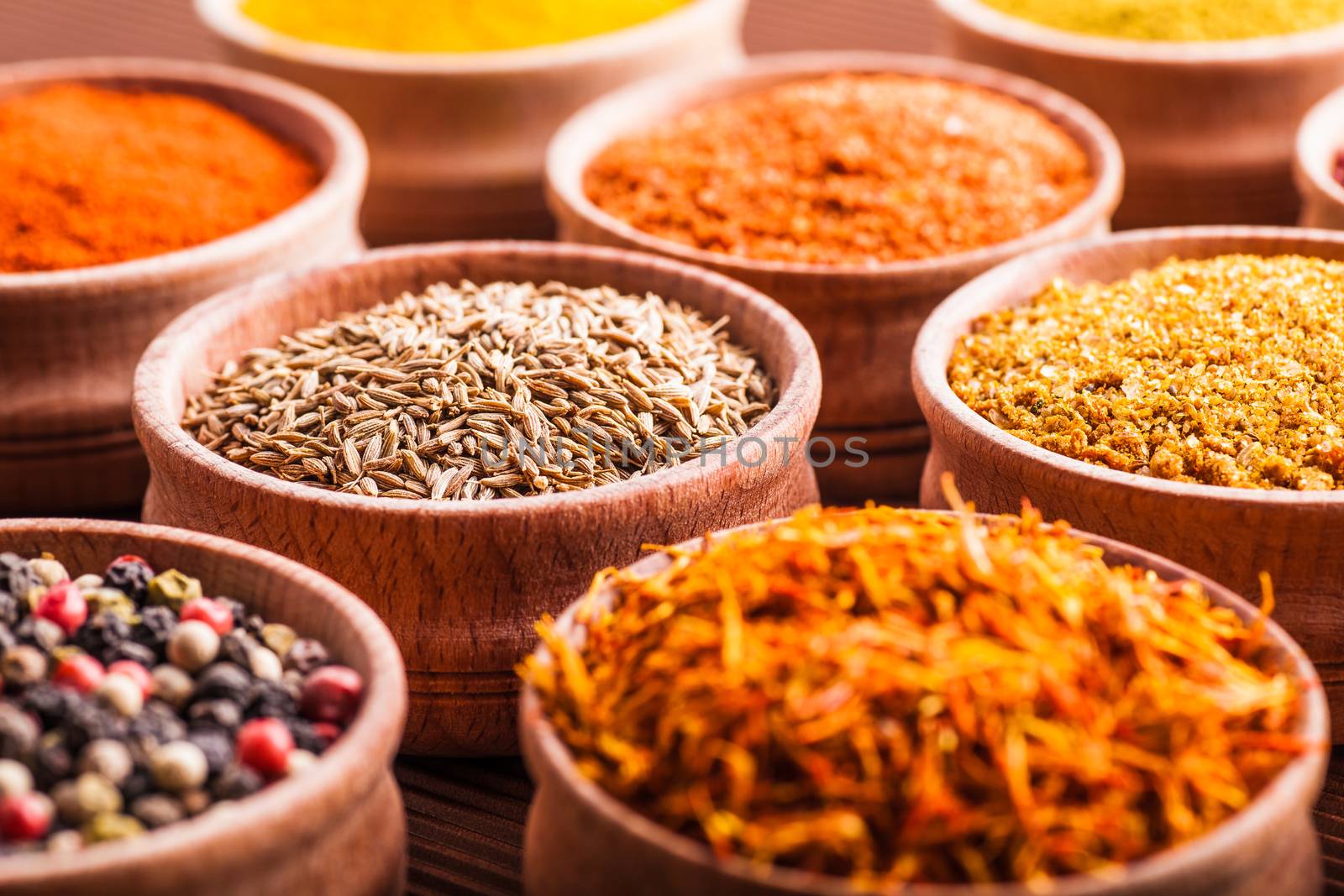spices in a wooden bowl close-up on a brown background