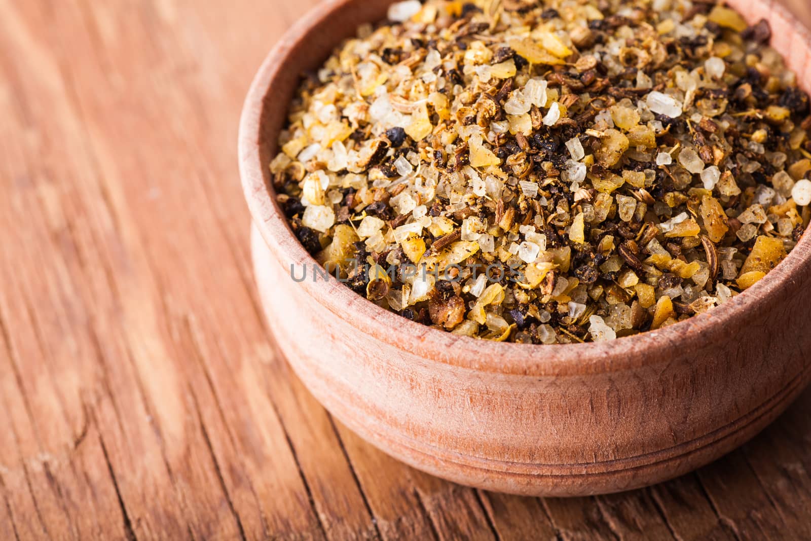 spice salt in a wooden bowl close-up on a vintage background