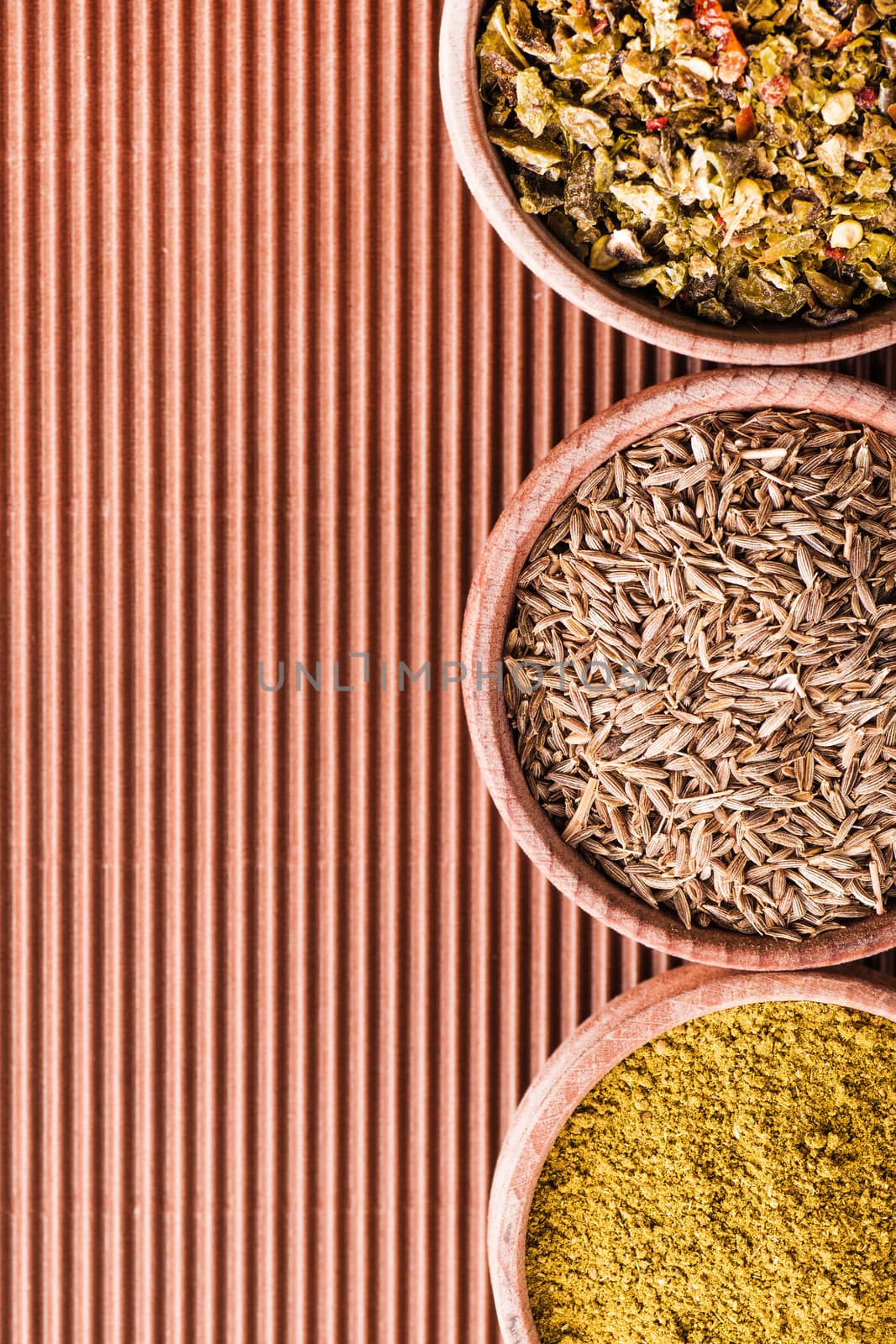 set cumin,hops-suneli,paprika in a wooden bowl close-up on a brown background