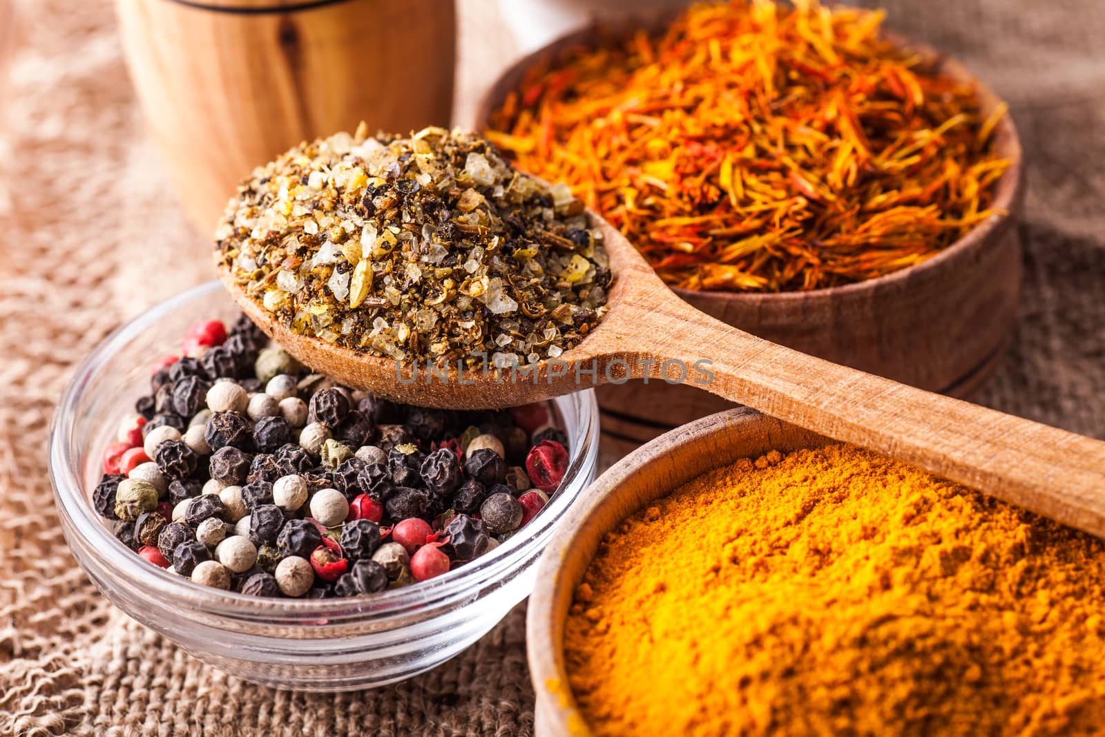 set dry spices in a wooden and glass bowls close-up on a vintage background