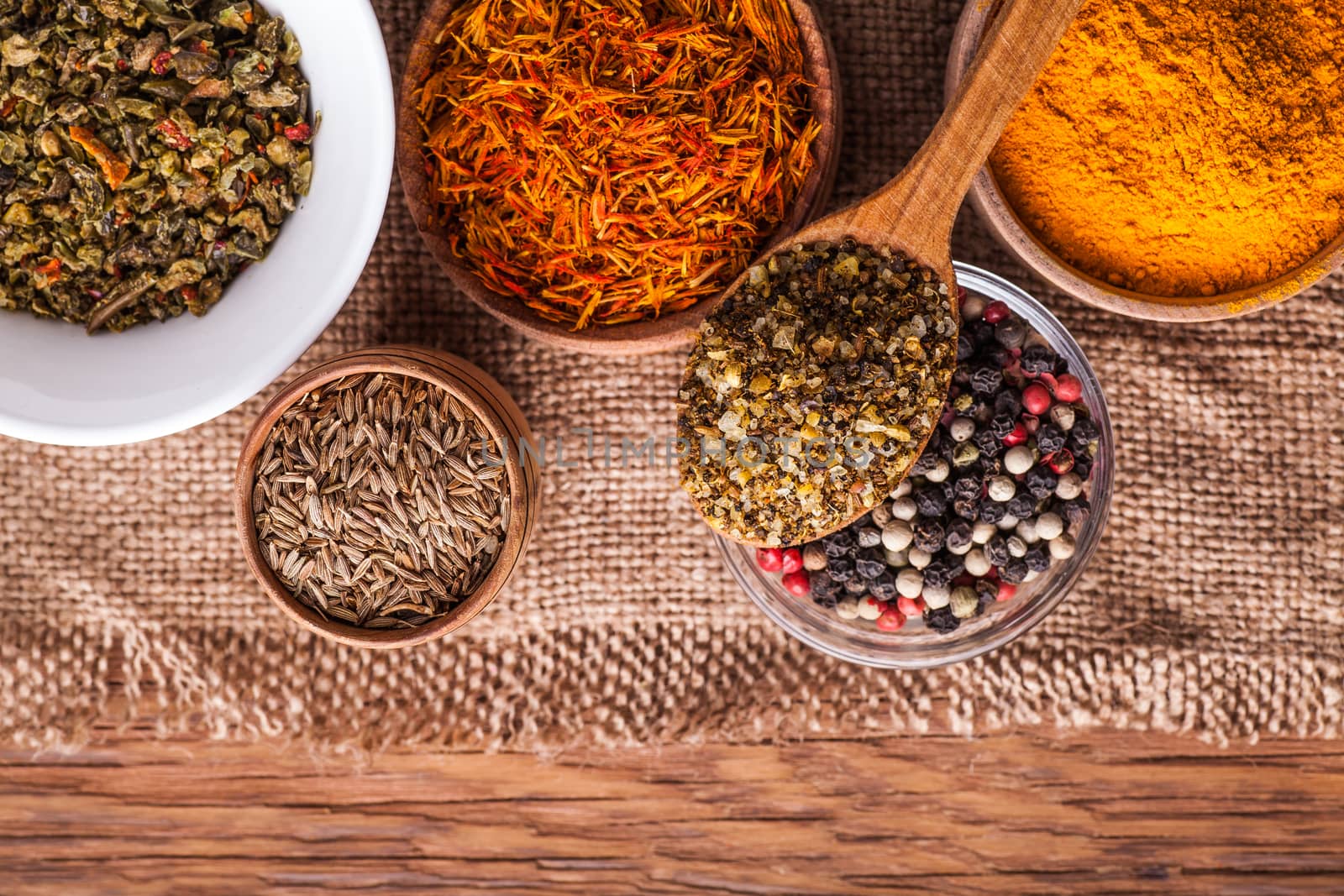 set dry spices in a wooden and glass bowls on a vintage background