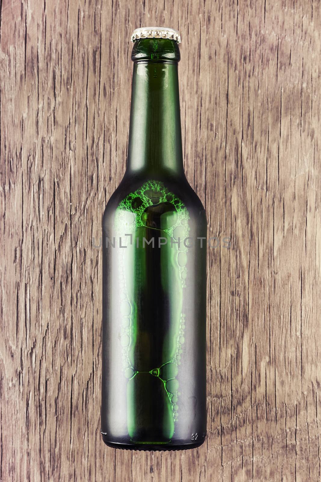 glass bottle of beer on a wooden background
