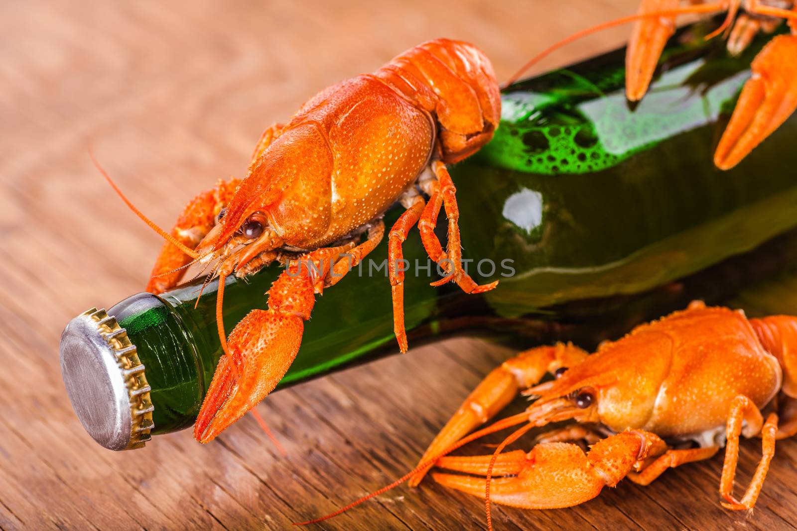 beer in a glass bottle and crayfish close-up on wooden background