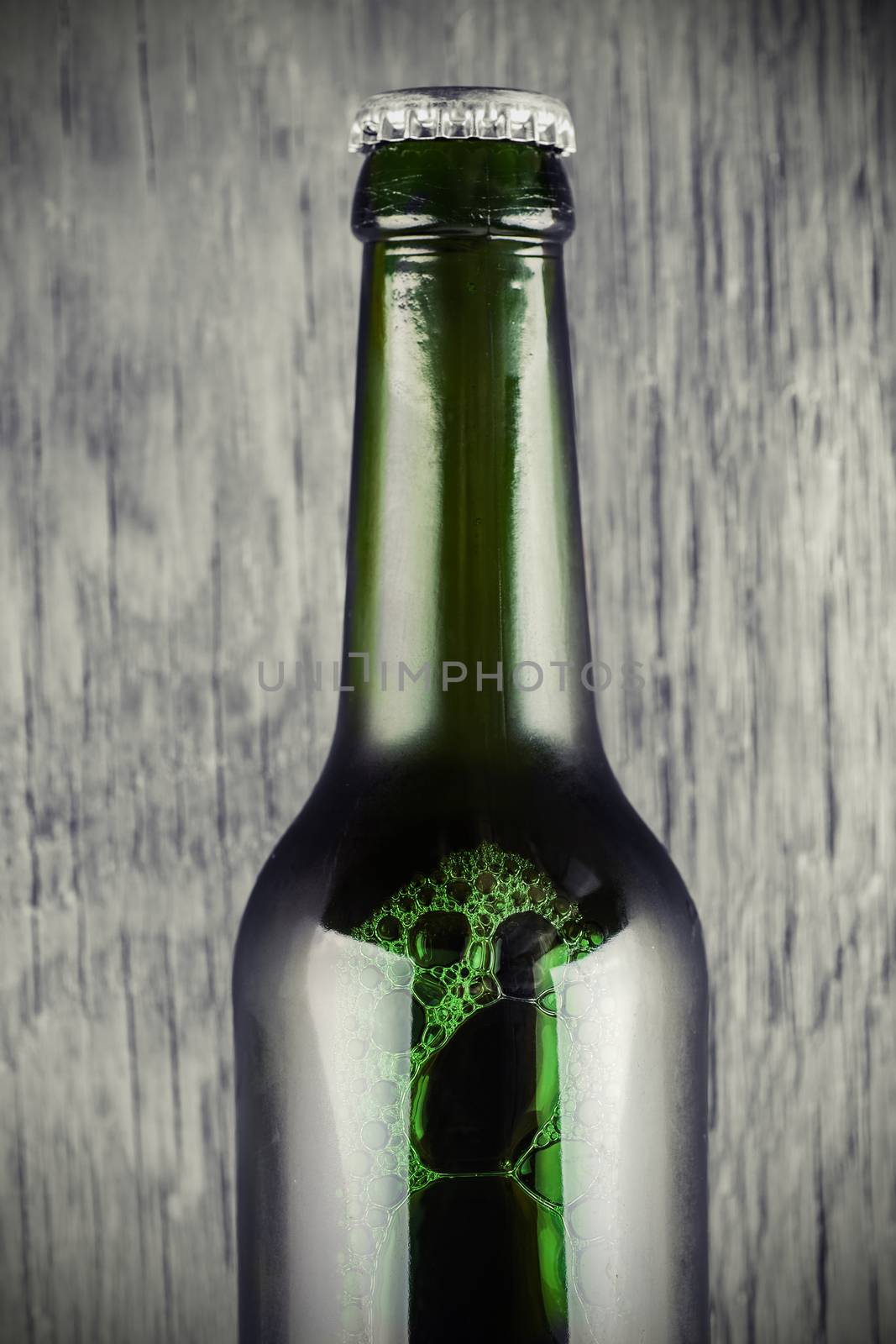 glass bottle of beer close-up on a wooden background