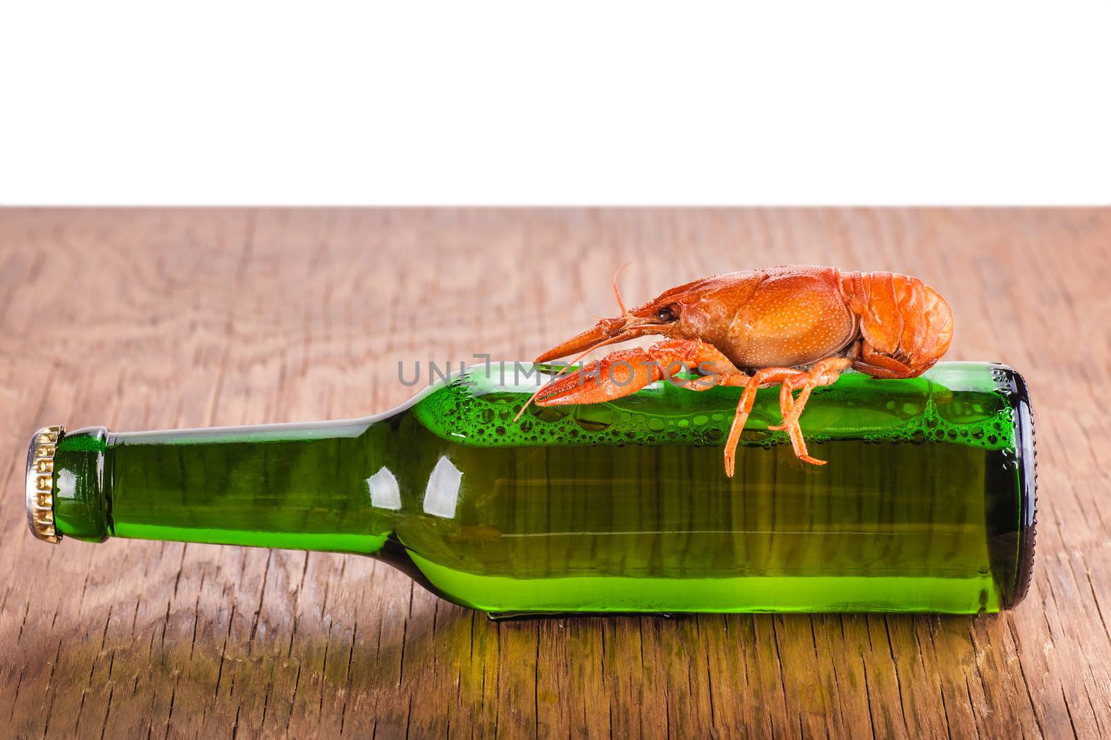 glass bottle of beer and crayfish on a white background