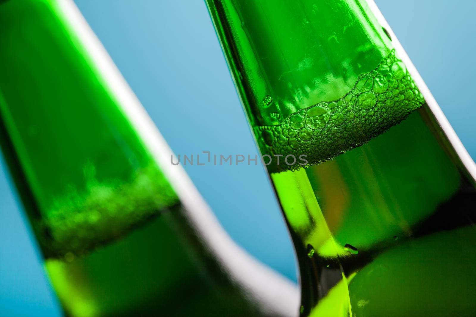 lager beer in glass bottle close-up on a blue background