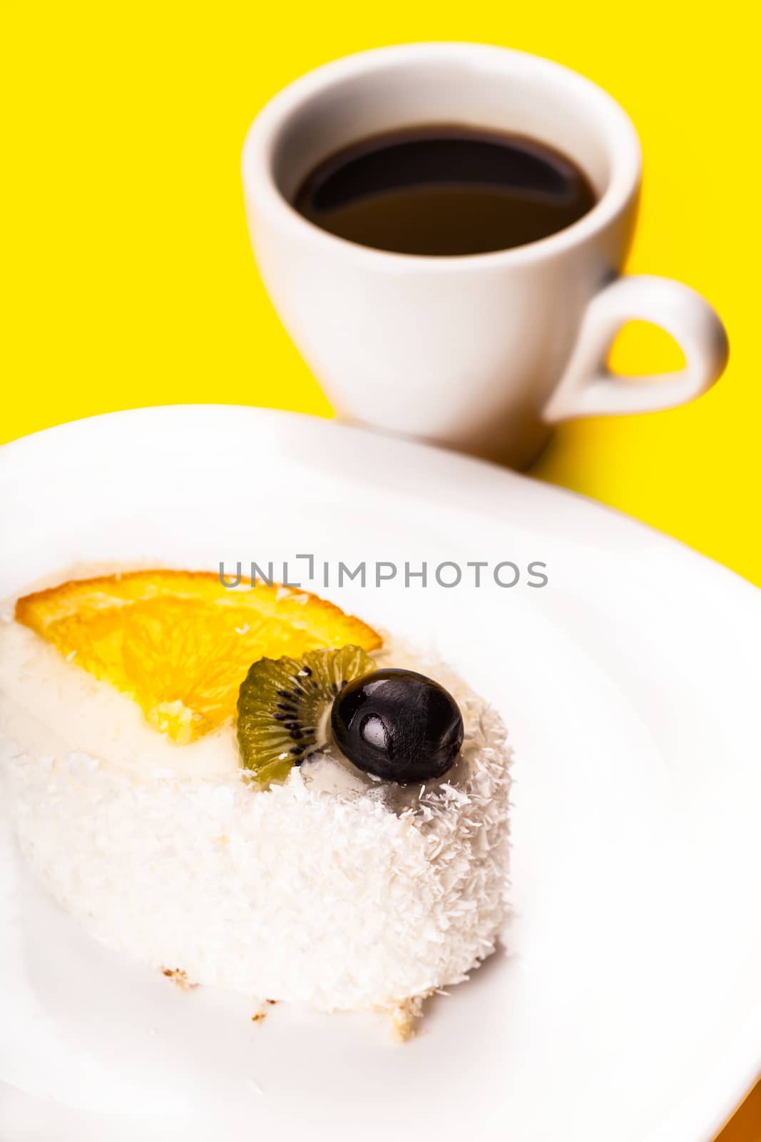 coconut piece of cake and coffee cup on a yellow background