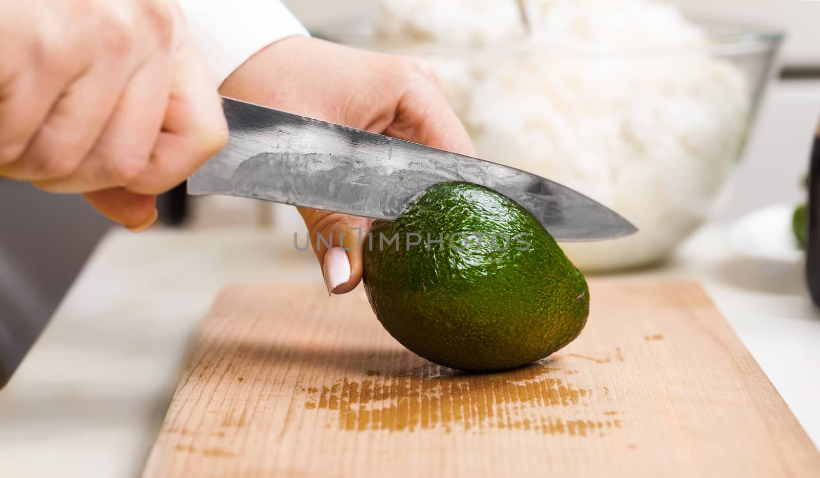 cuts the avocado closeup on a wooden board