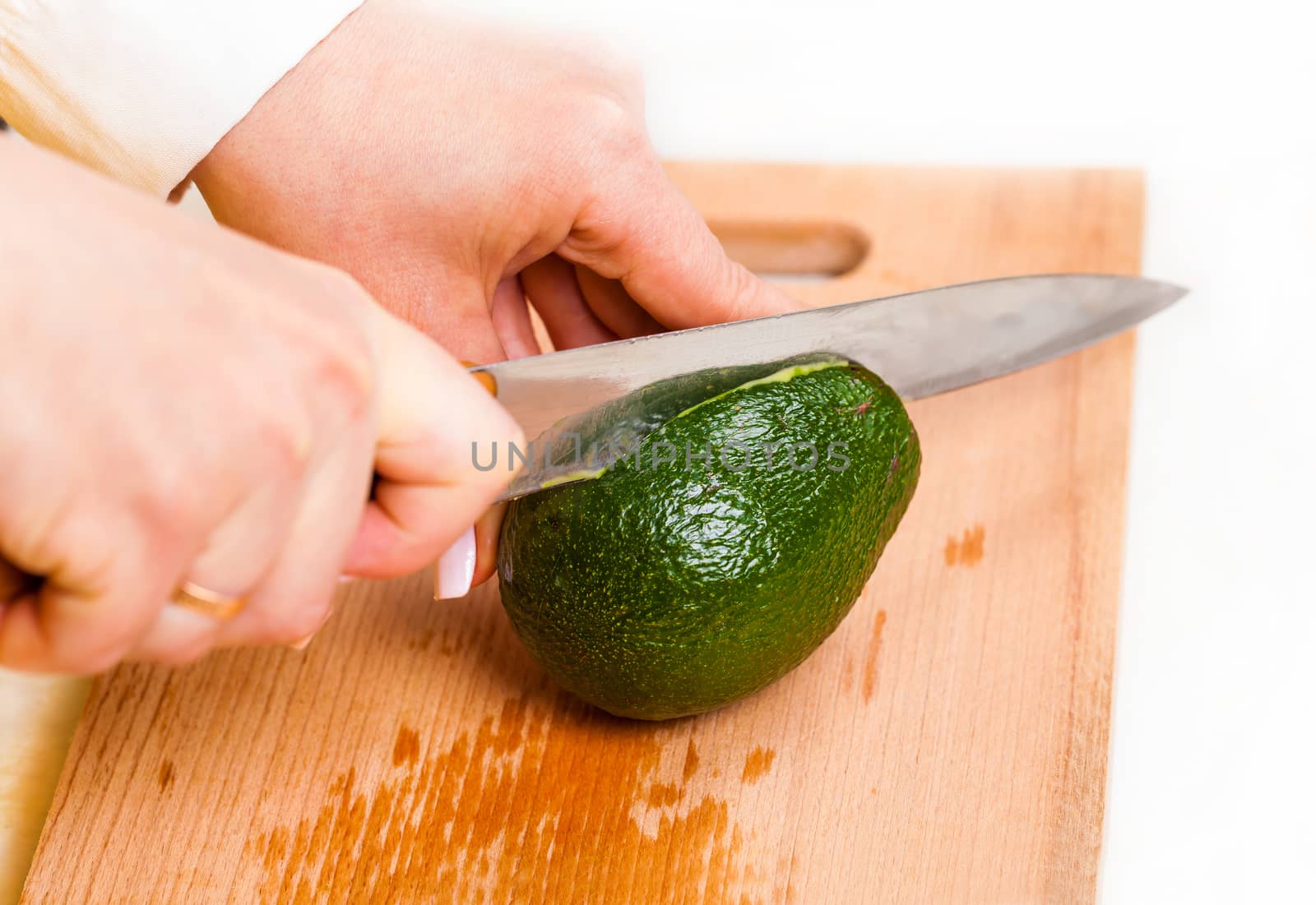 chef cuts the avocado closeup on a wooden board