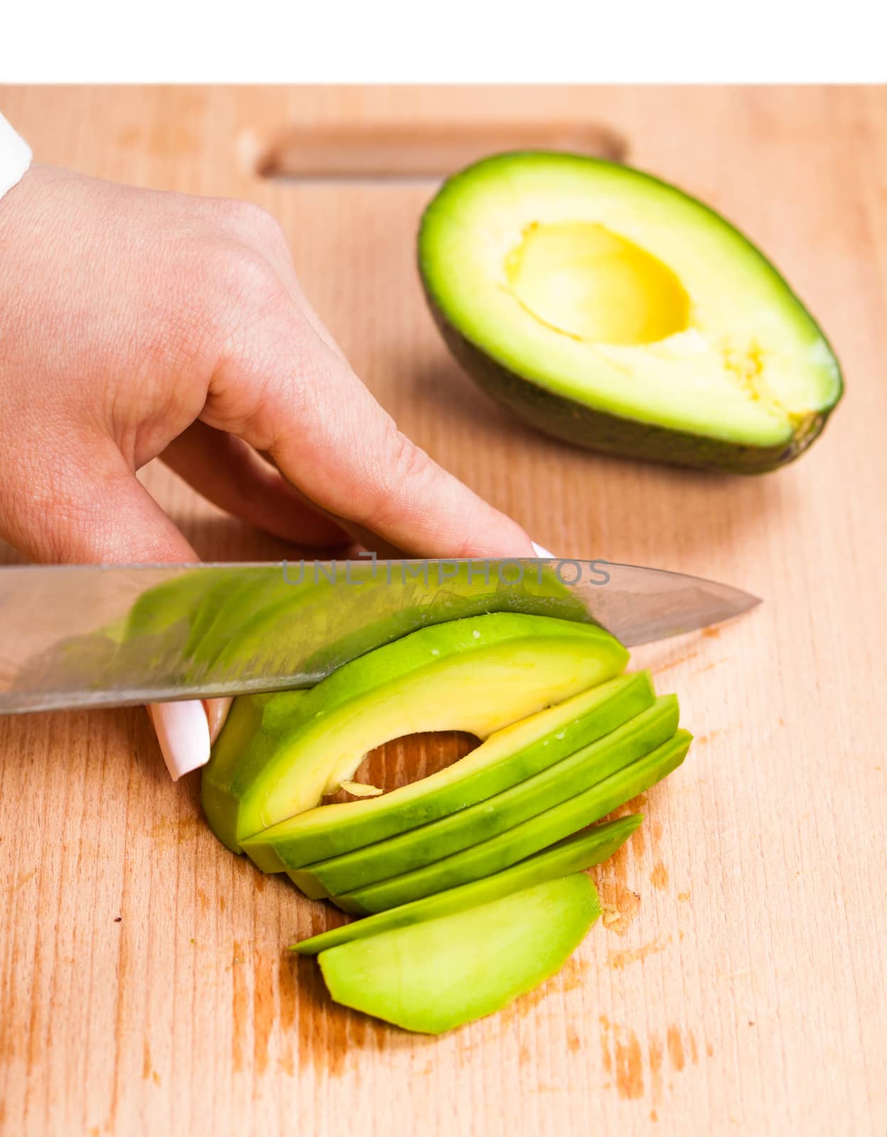  slicing fresh avocado close-up on a wooden board