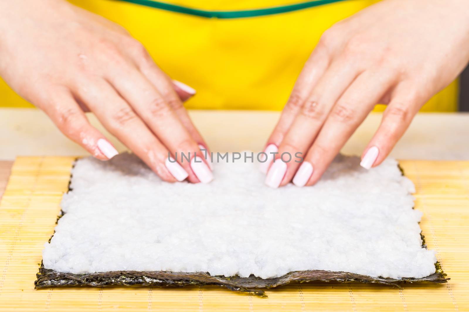 cook places the rice on the nori sheet