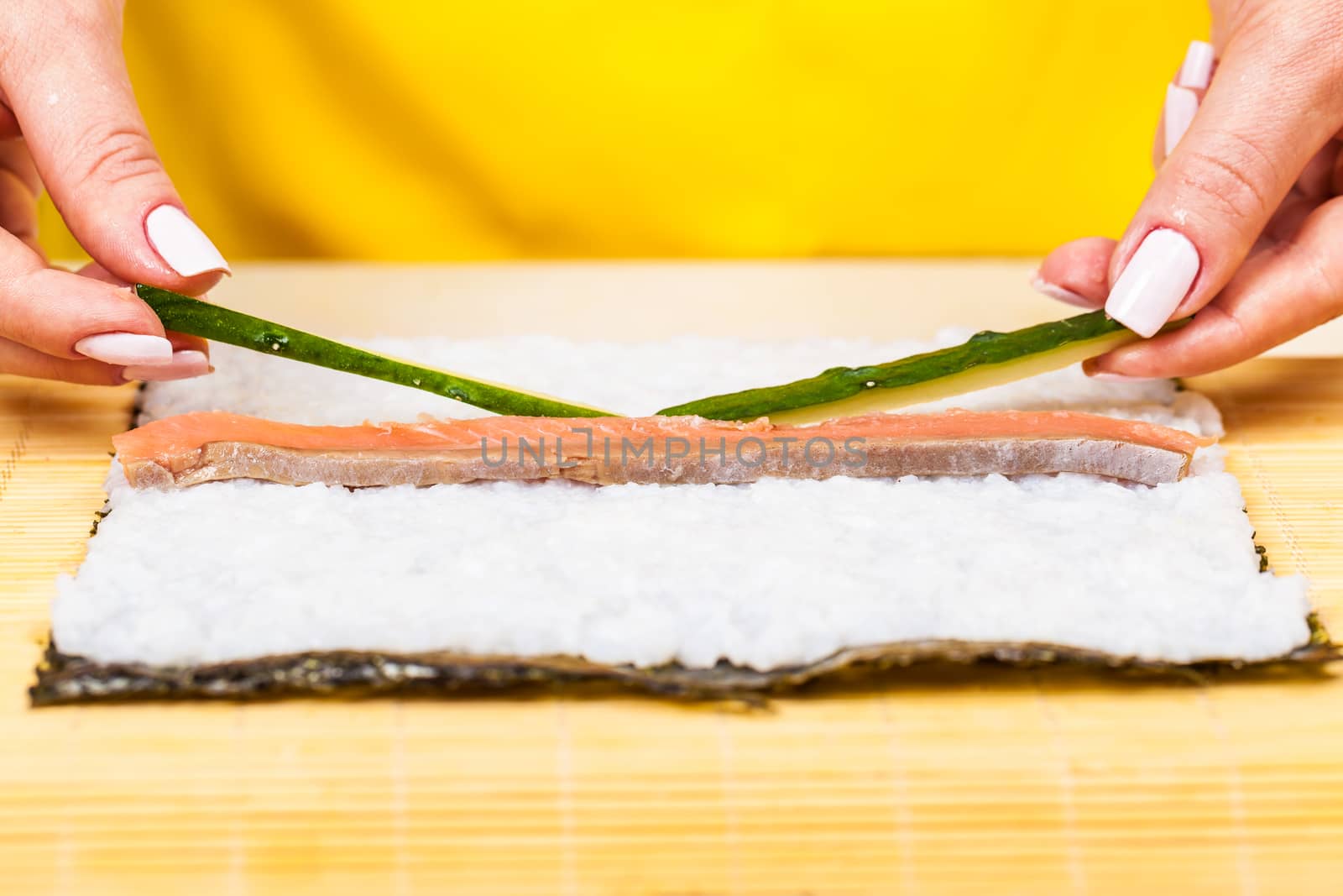 chef adds fresh cucumbers on a wooden board