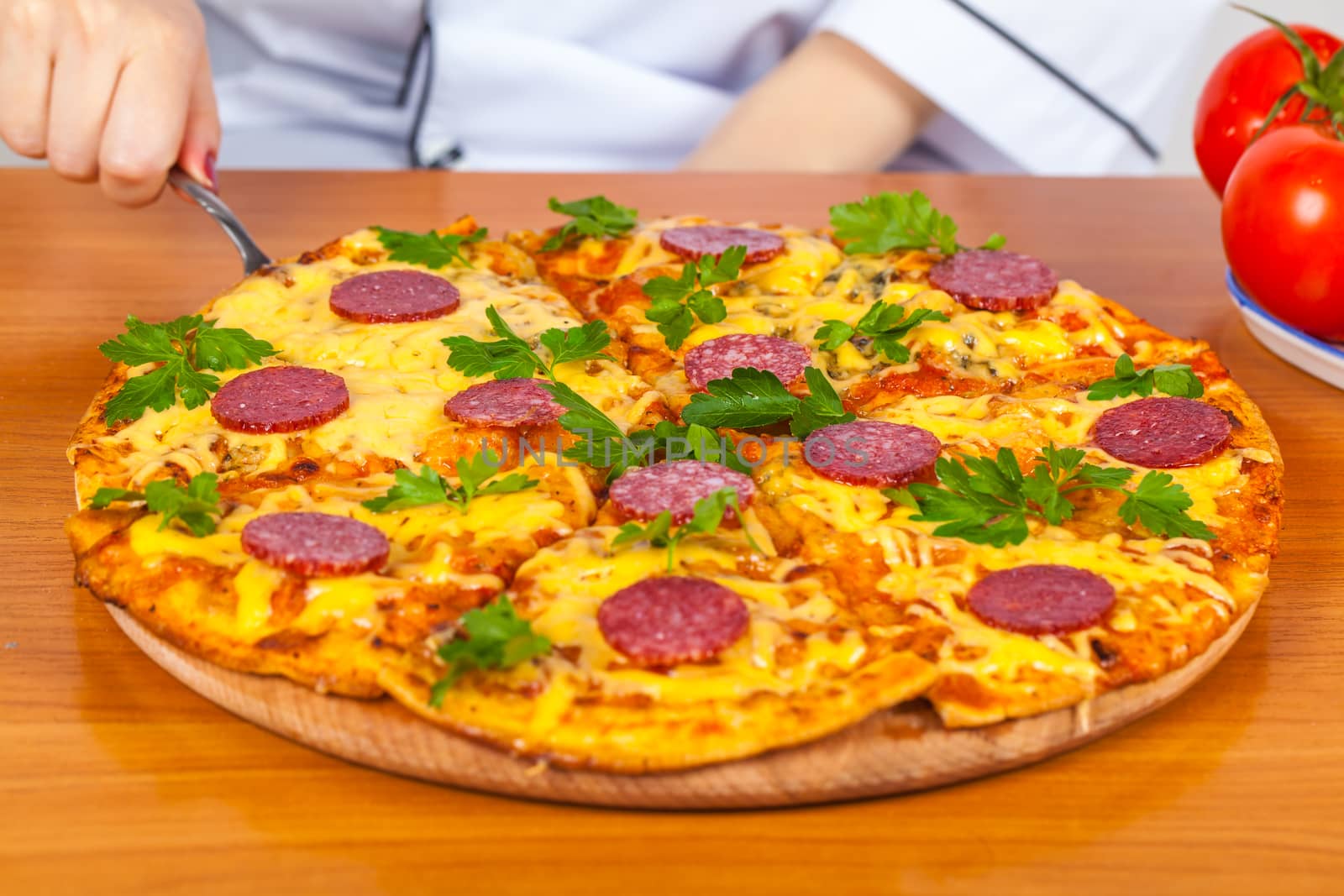 chef holds a slice of pizza on the blade