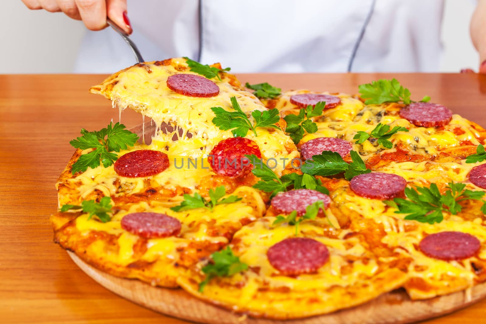 chef holds a slice of pizza on the blade