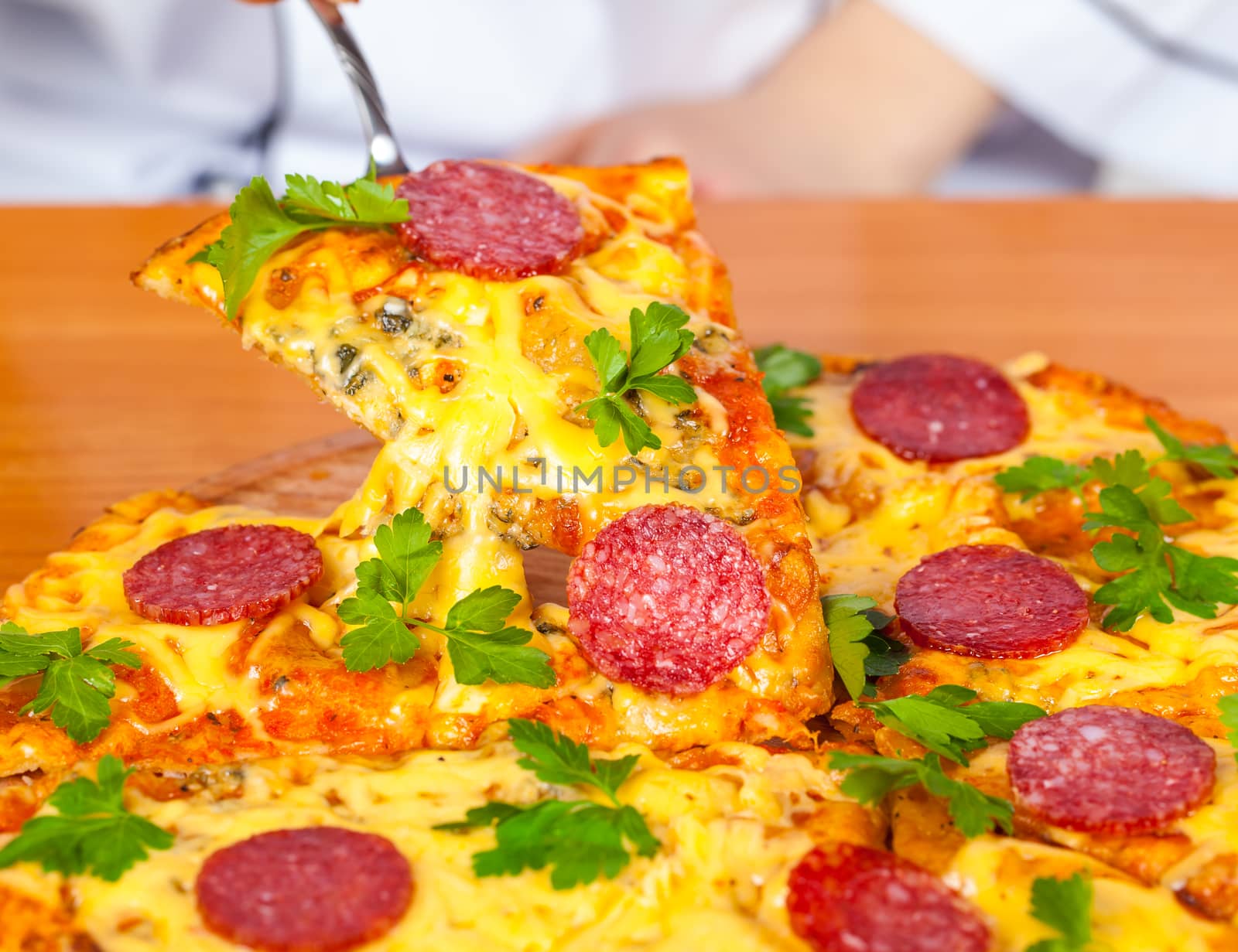 slice pizza with salami closeup on wooden background