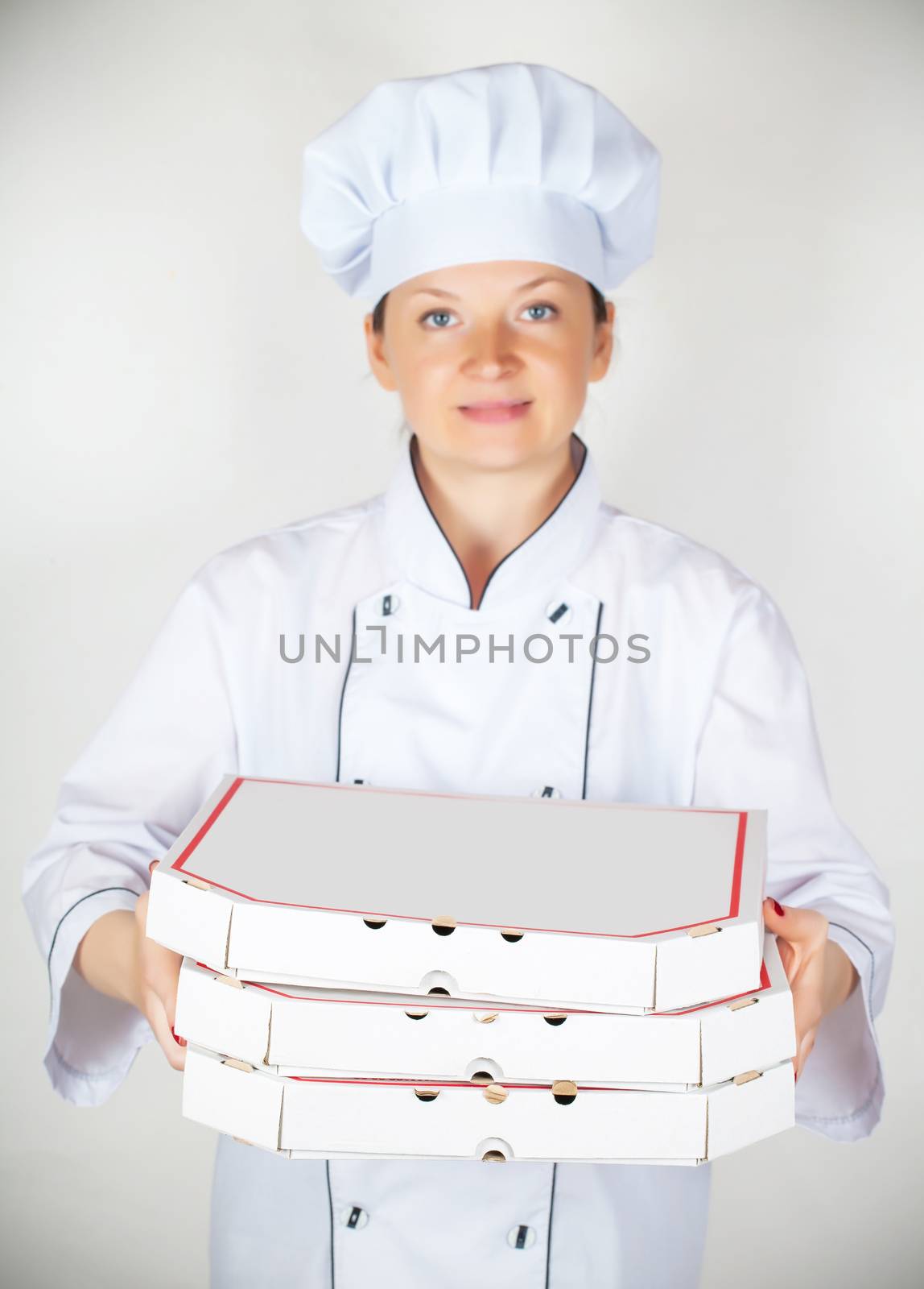 cook with a pizza in the box on a light background