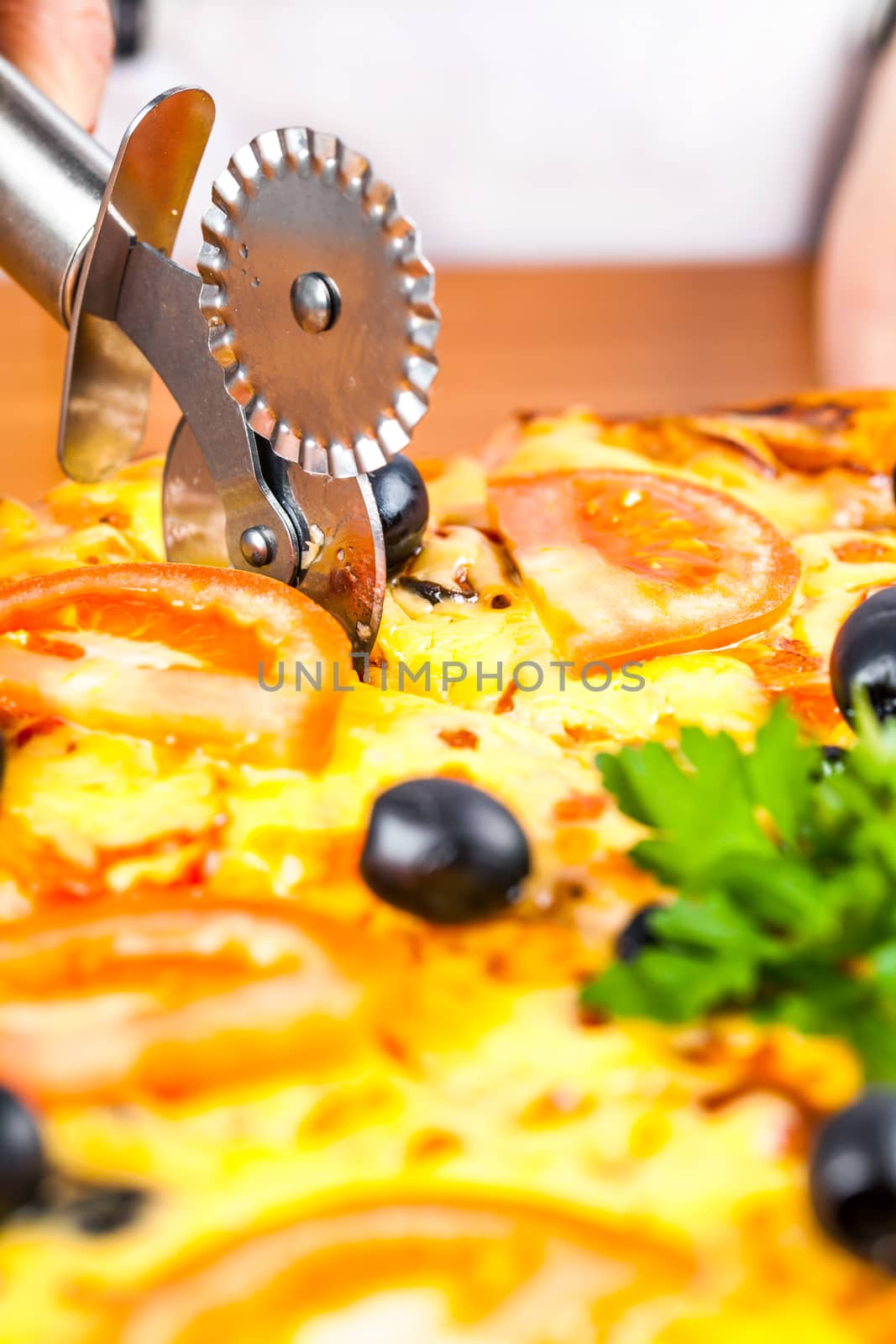 chef knife cuts fresh hot vegetable pizza closeup