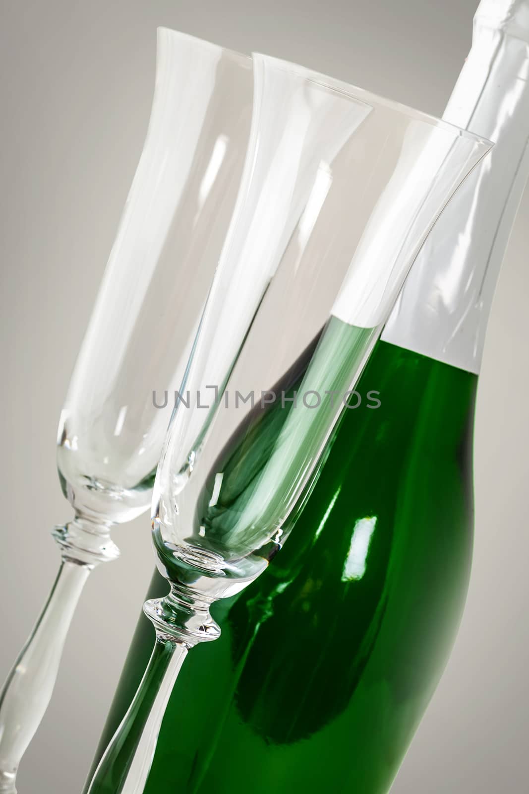 a bottle of sparkling champagne with glasses on a light background