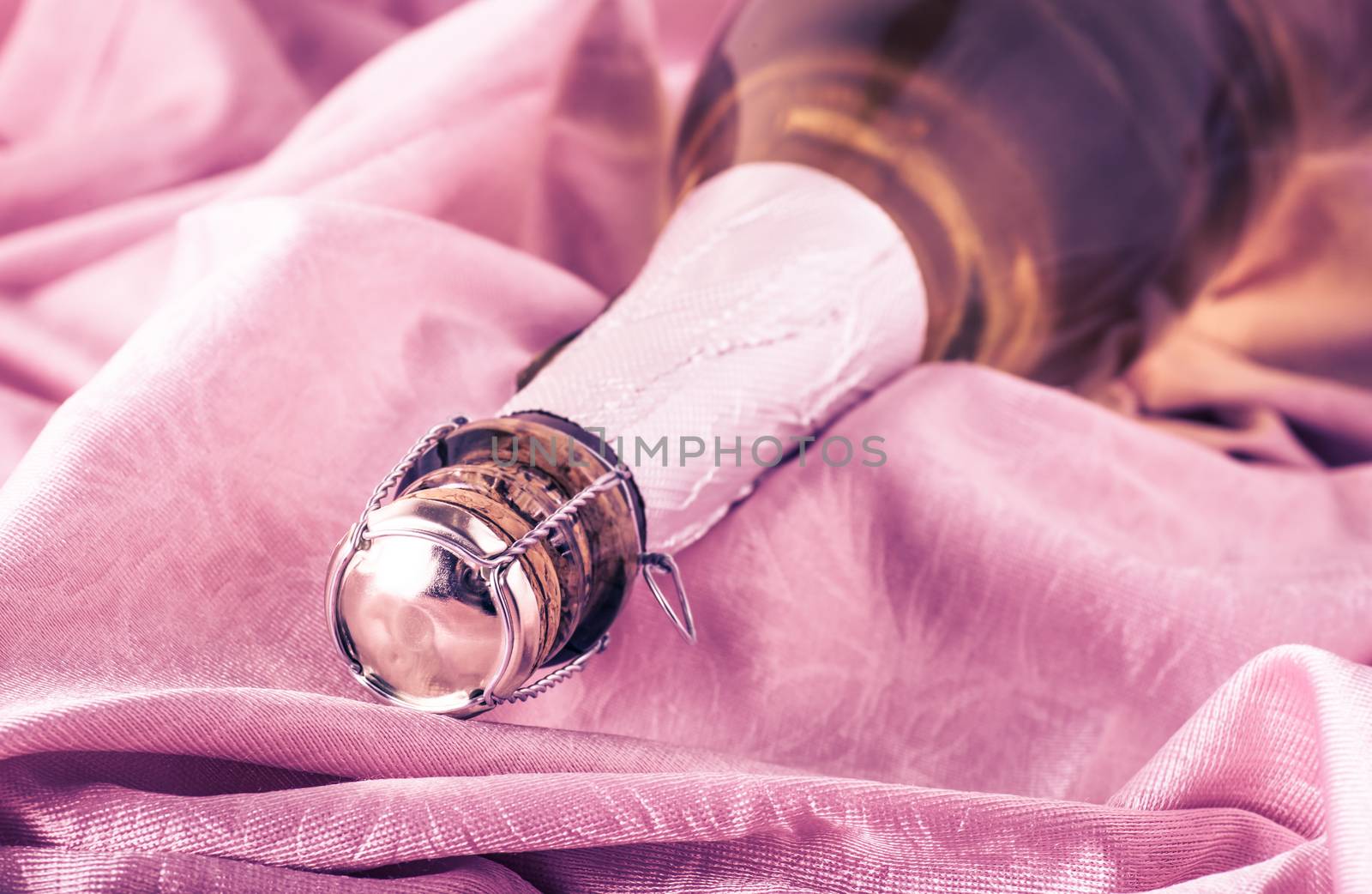 sparkling champagne in the bottle lying on the thin fabric