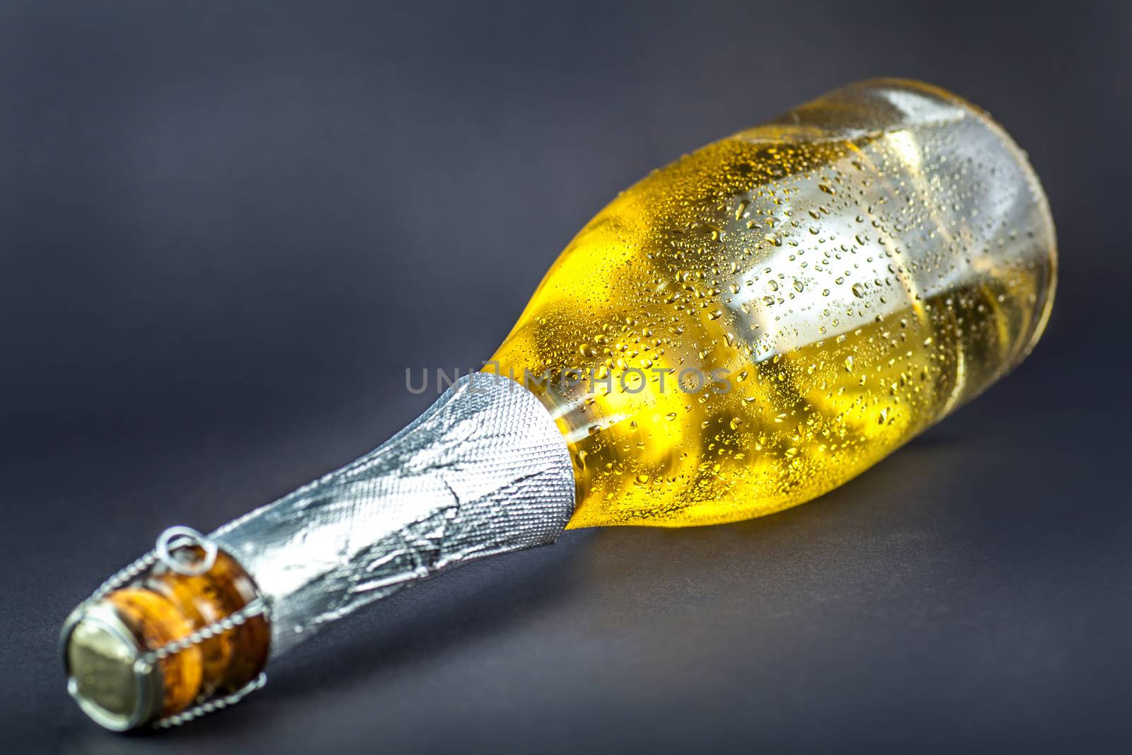 bottle in the drops of water on a dark background