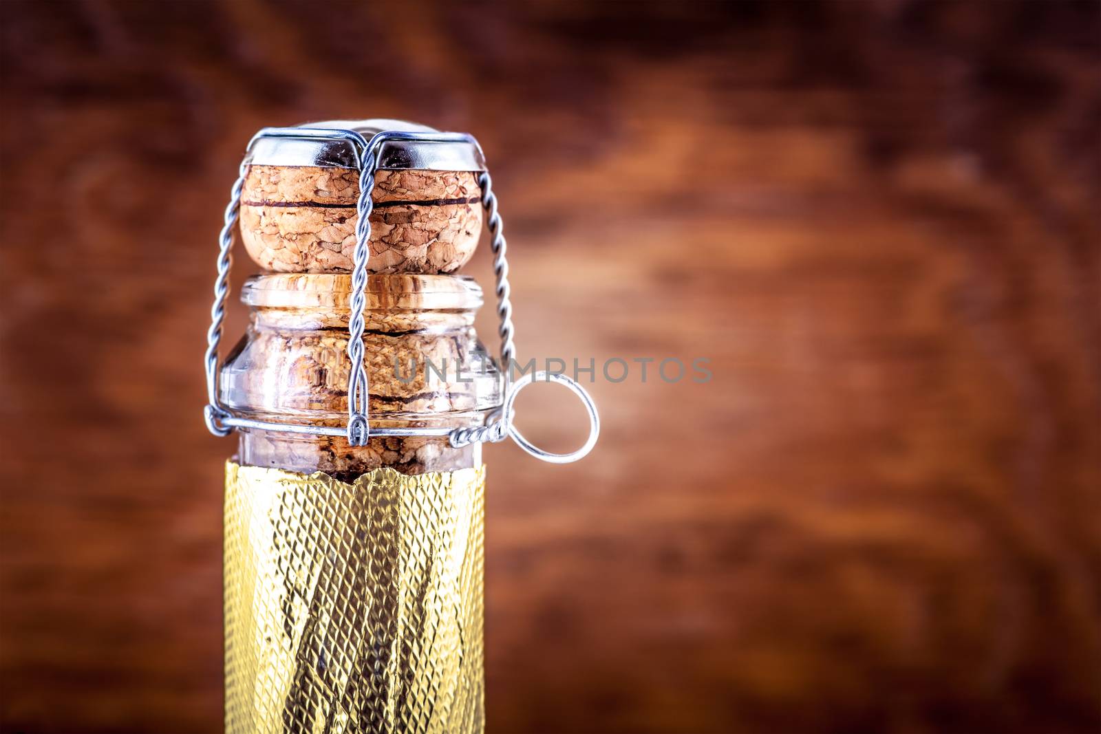 neck of a bottle of champagne on a wooden background