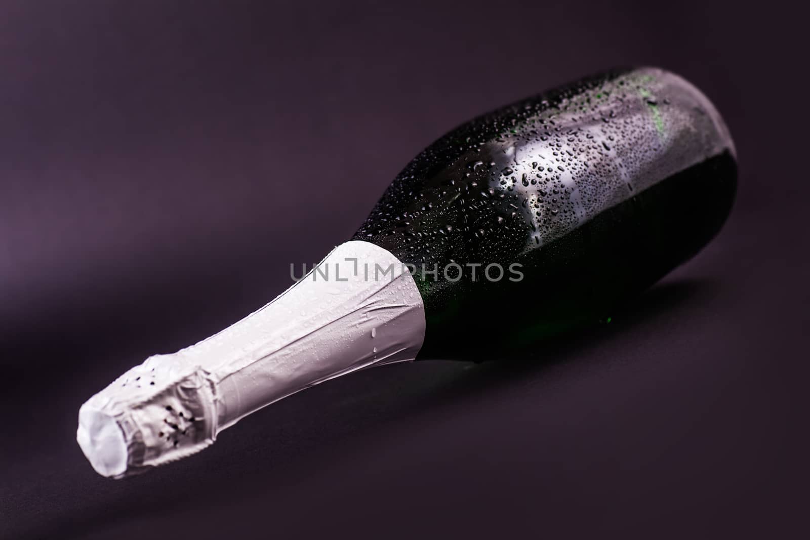 bottle of champagne lying on a dark background