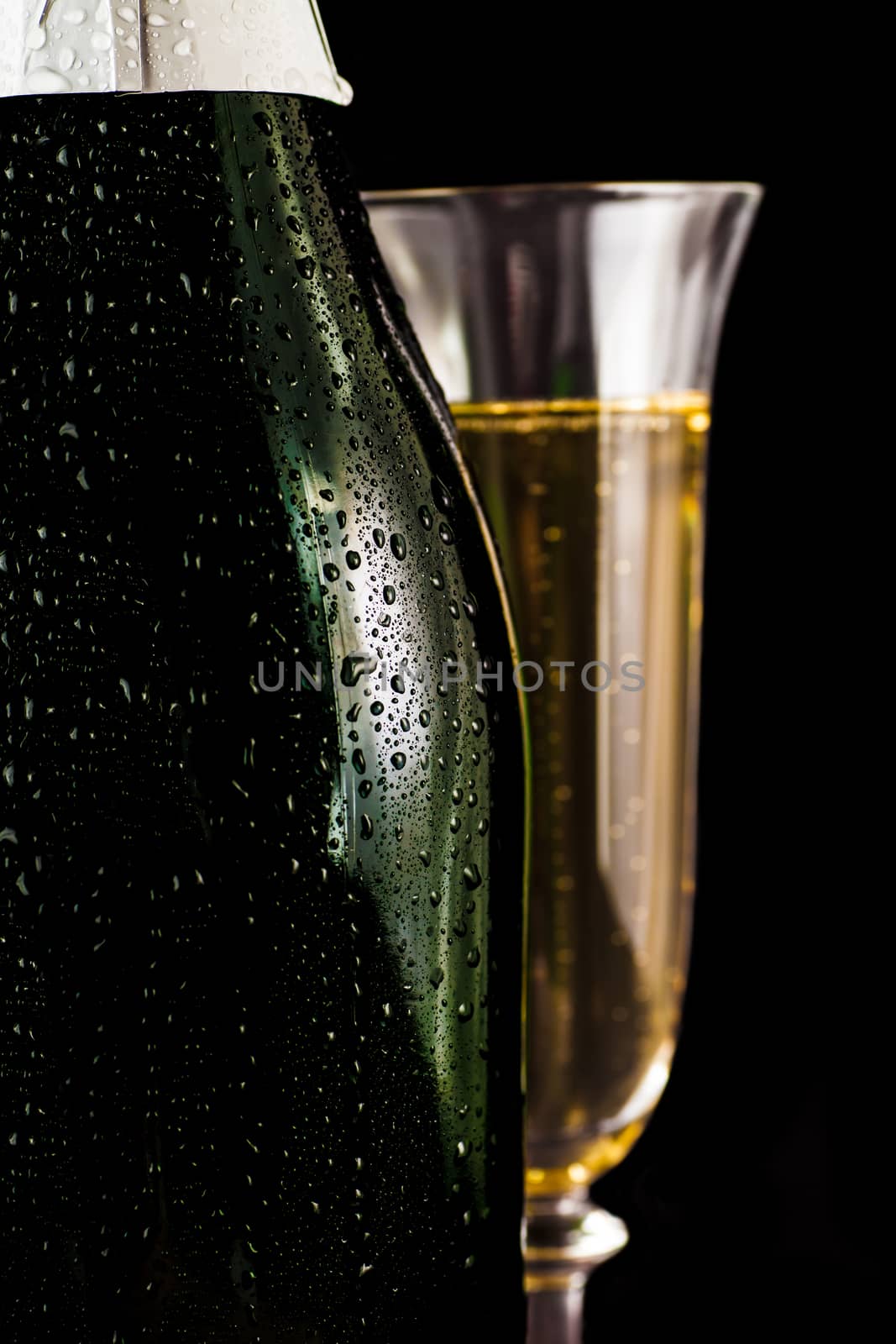 bottle of champagne with a glass closeup on a dark background