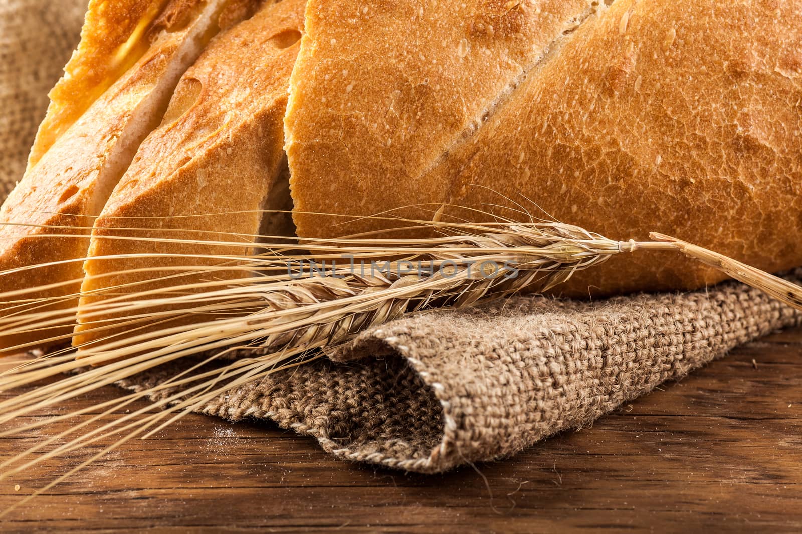 ear of wheat on a background of sliced white bread