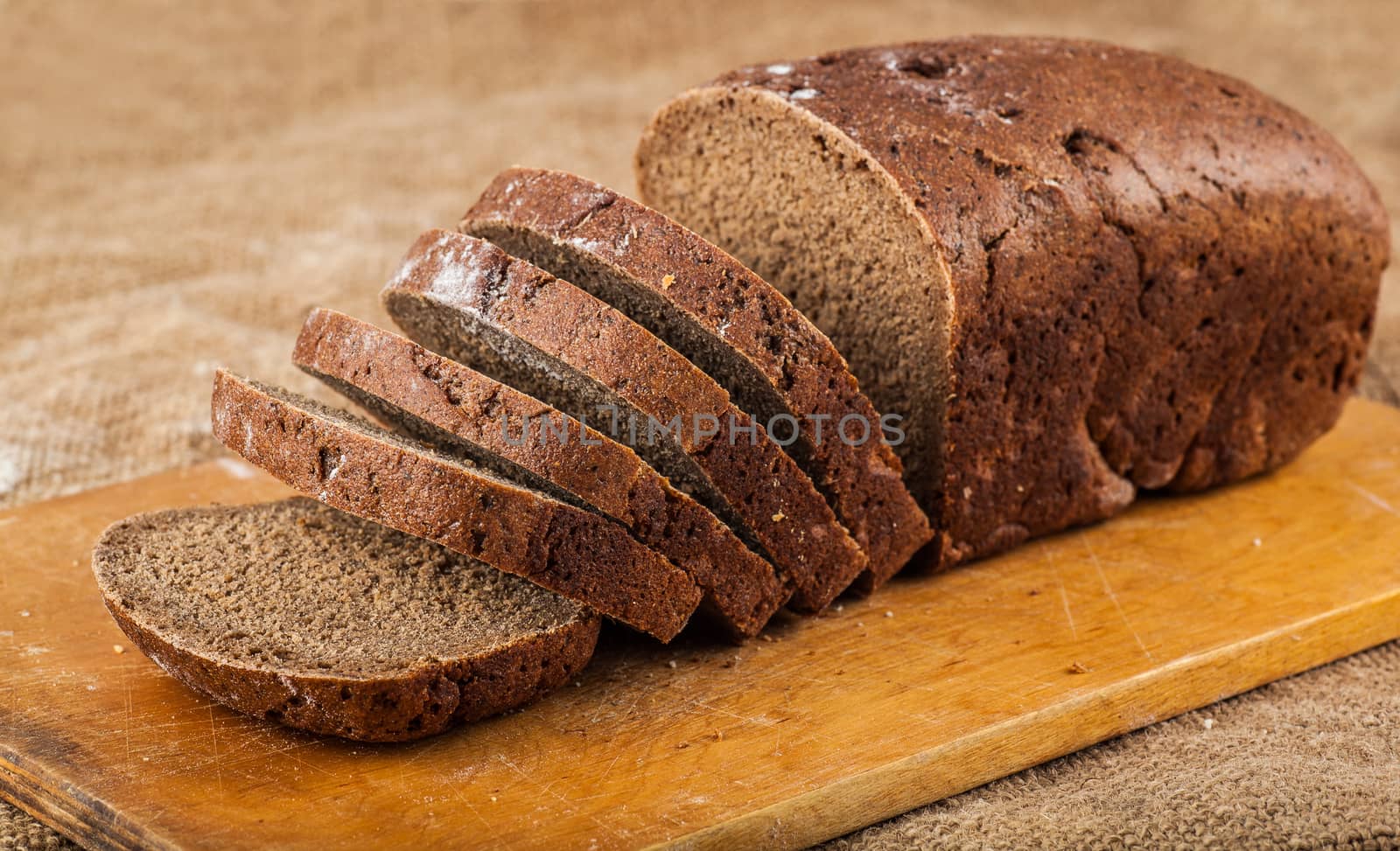 sliced loaf brown bread on a wooden board