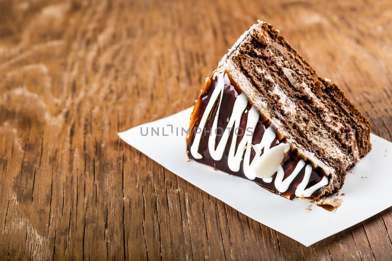 slice of chocolate cream cake on a wooden background