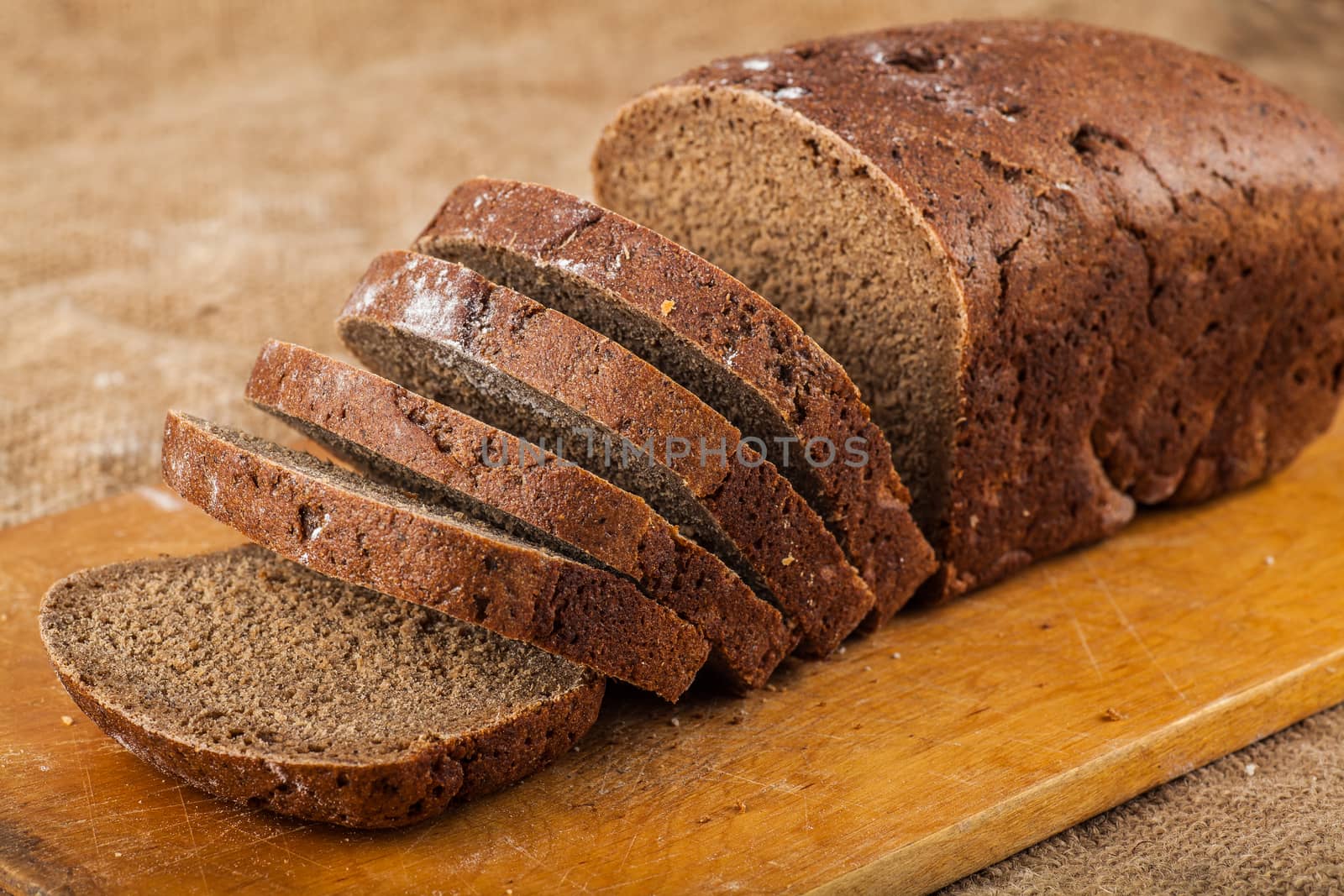sliced loaf rye bread on a wooden board