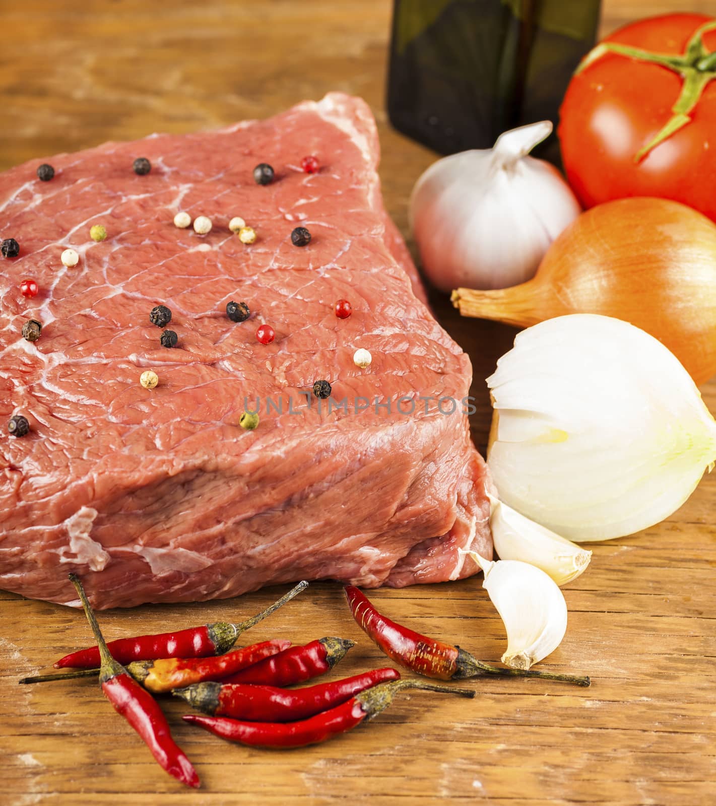 raw beef fillet with herbs closeup on wooden background