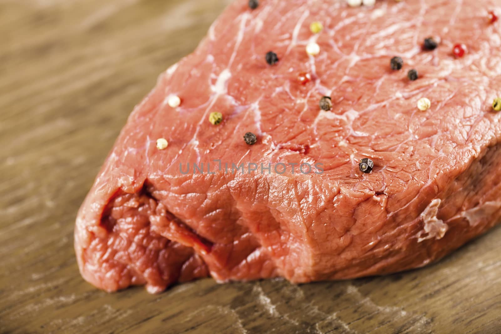 raw beef filet with spices on a wooden background