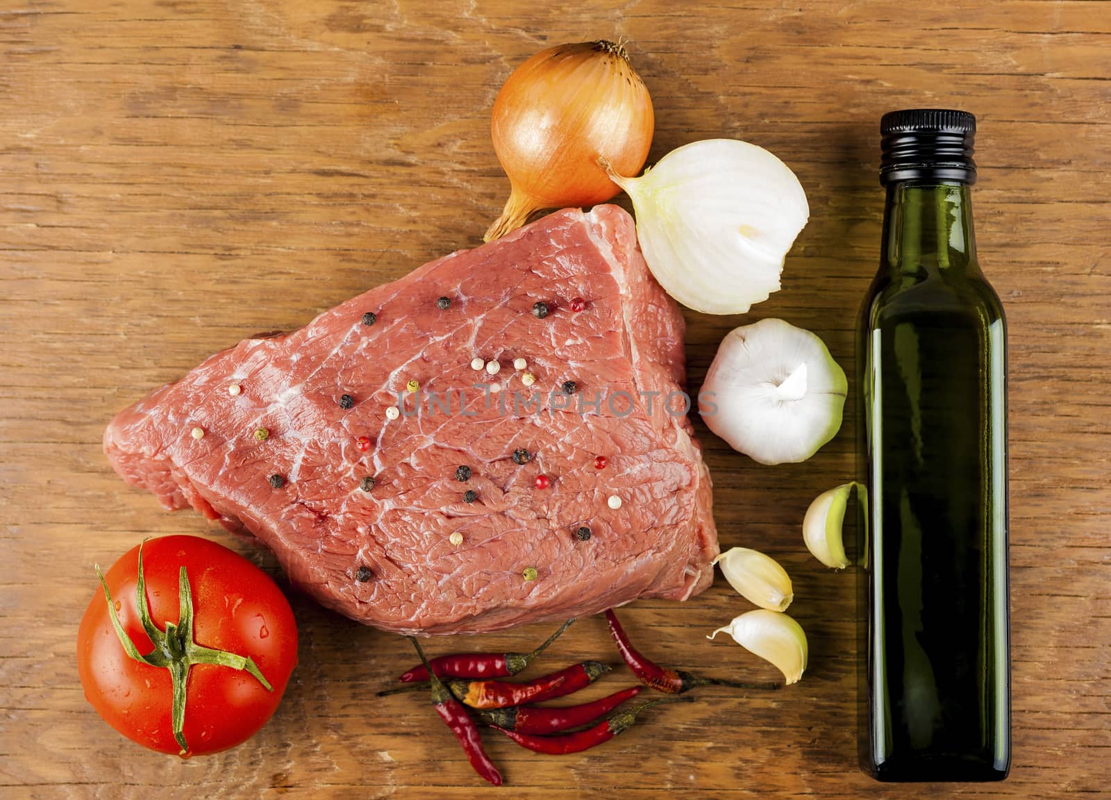 raw beef fillet with spices on a wooden background
