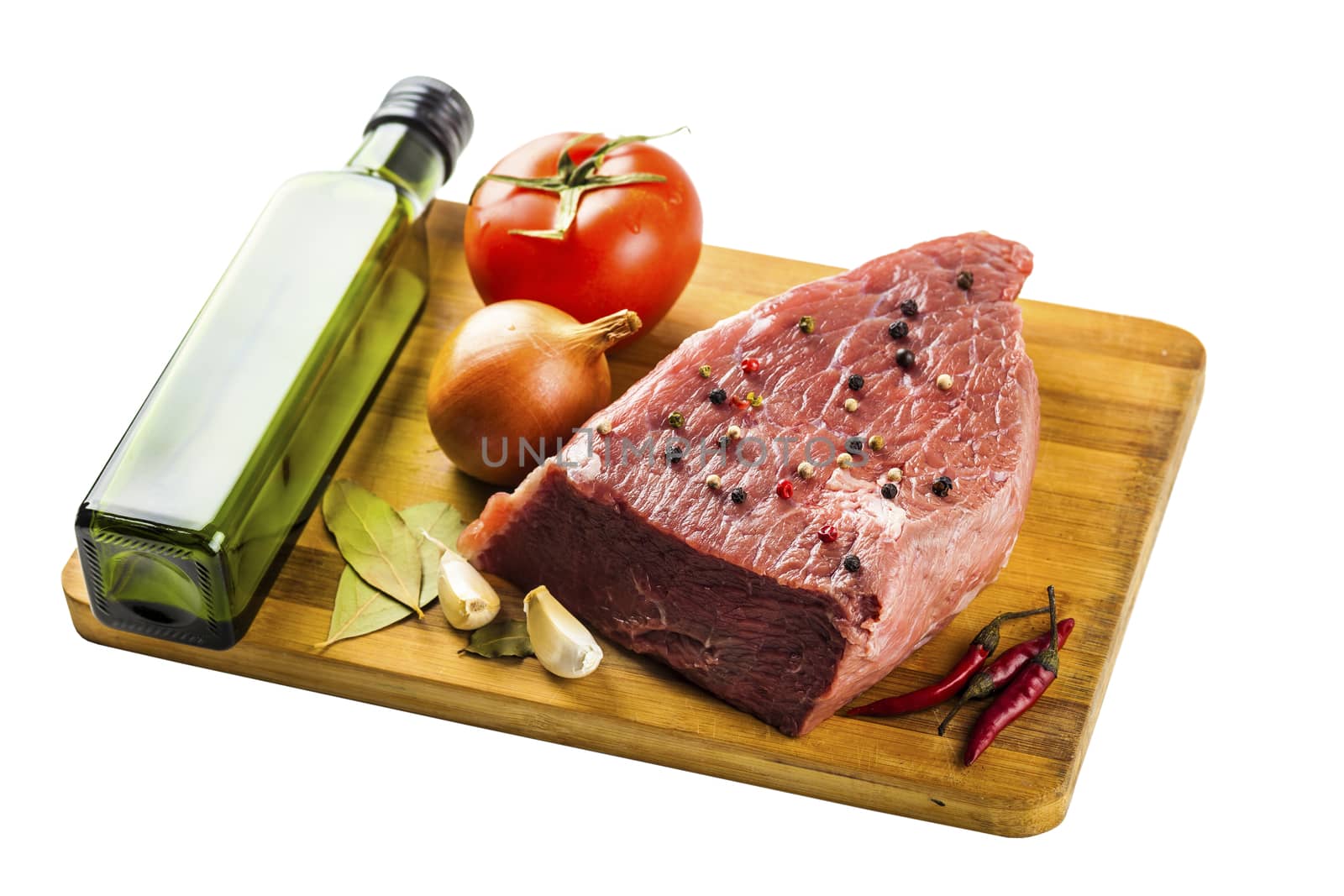 beef filet with spices and vegetables closeup on wooden board, isolated white background