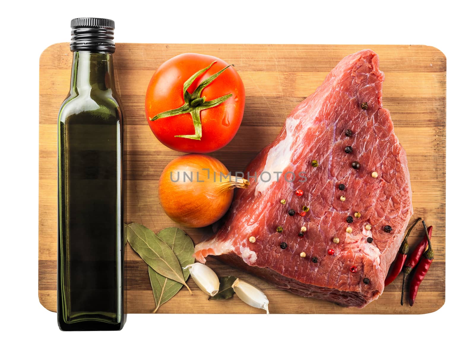 beef filet with spices and vegetables closeup on wooden board, white background
