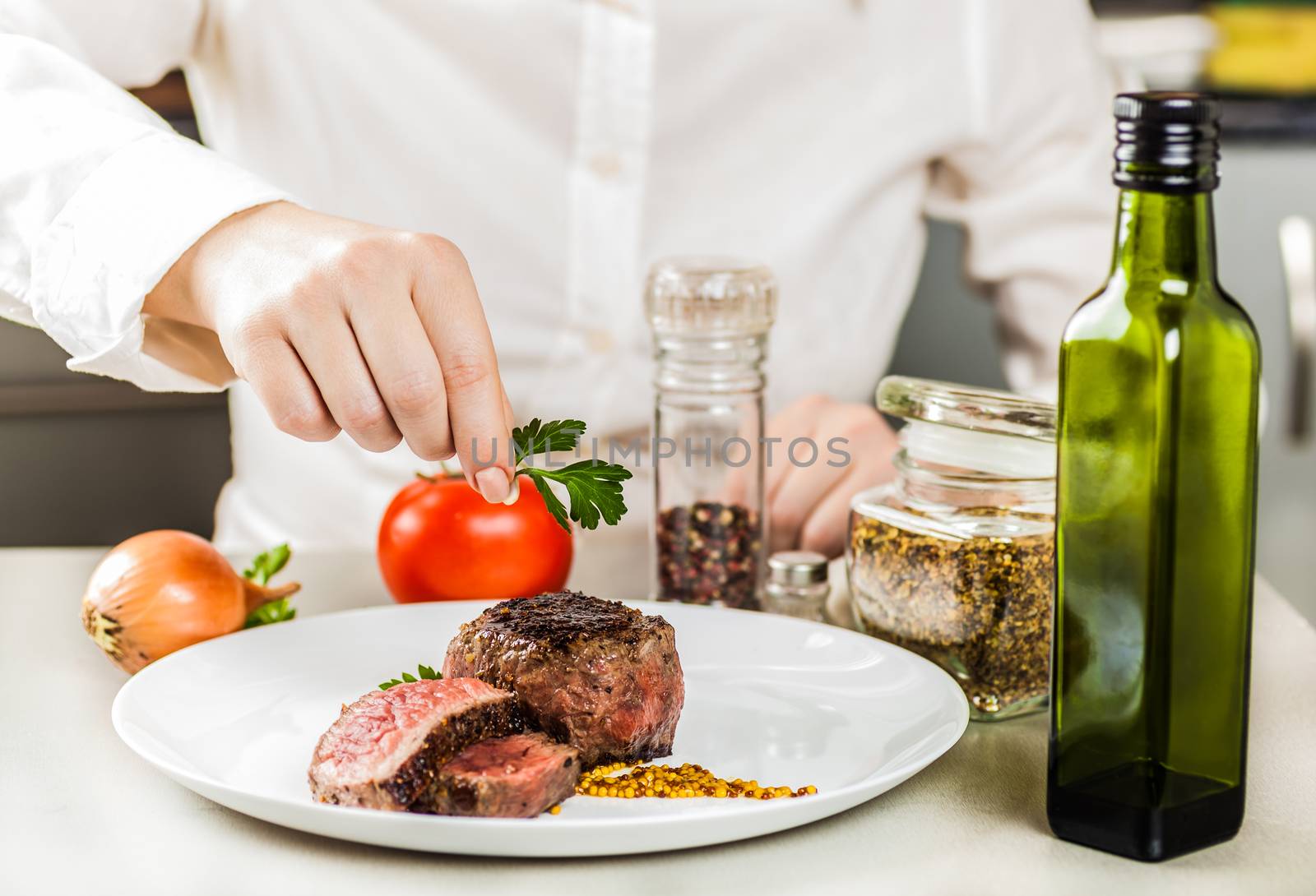 chef decorates greens ready fried medallions in a plate